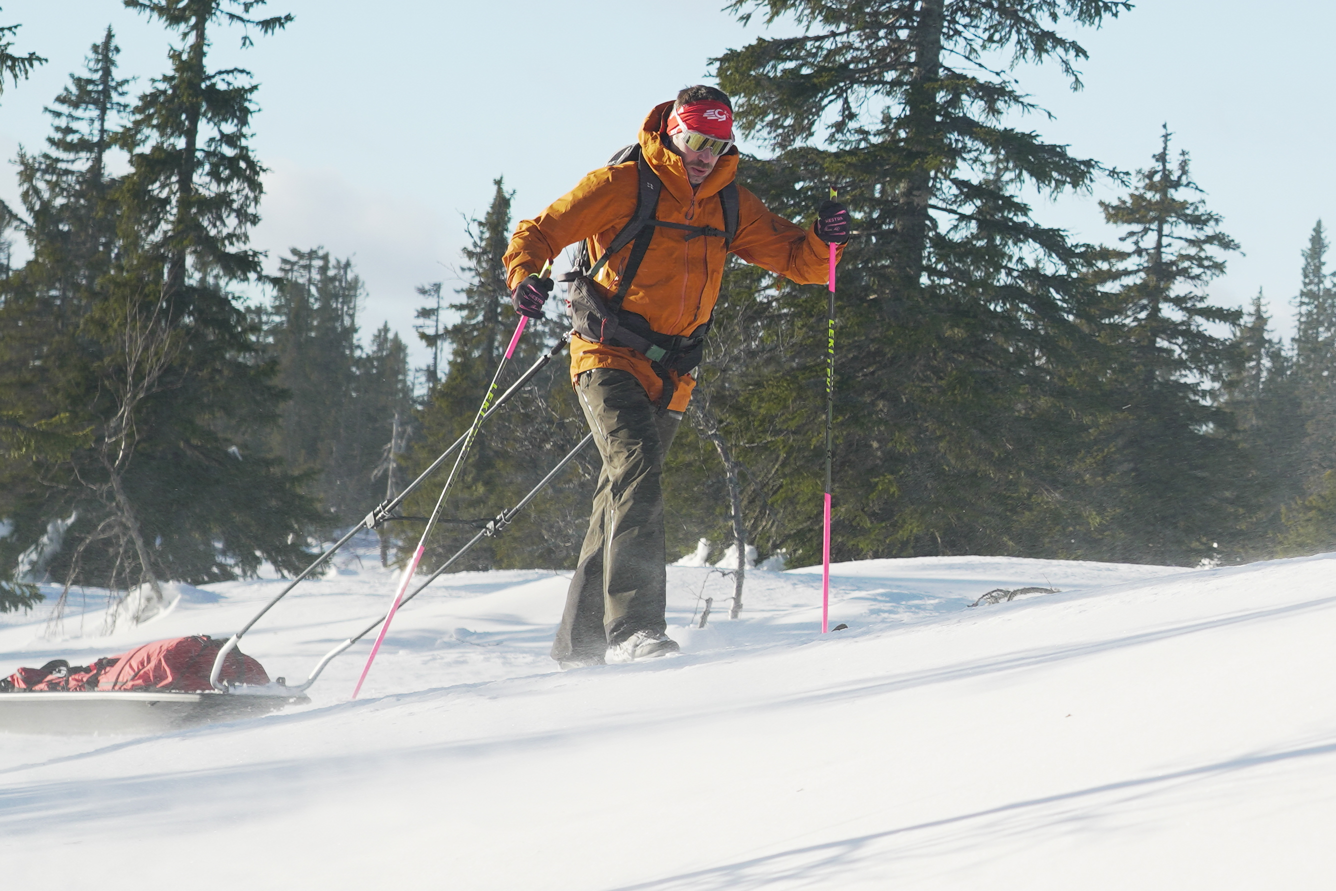 A man dragging a sled through the snow