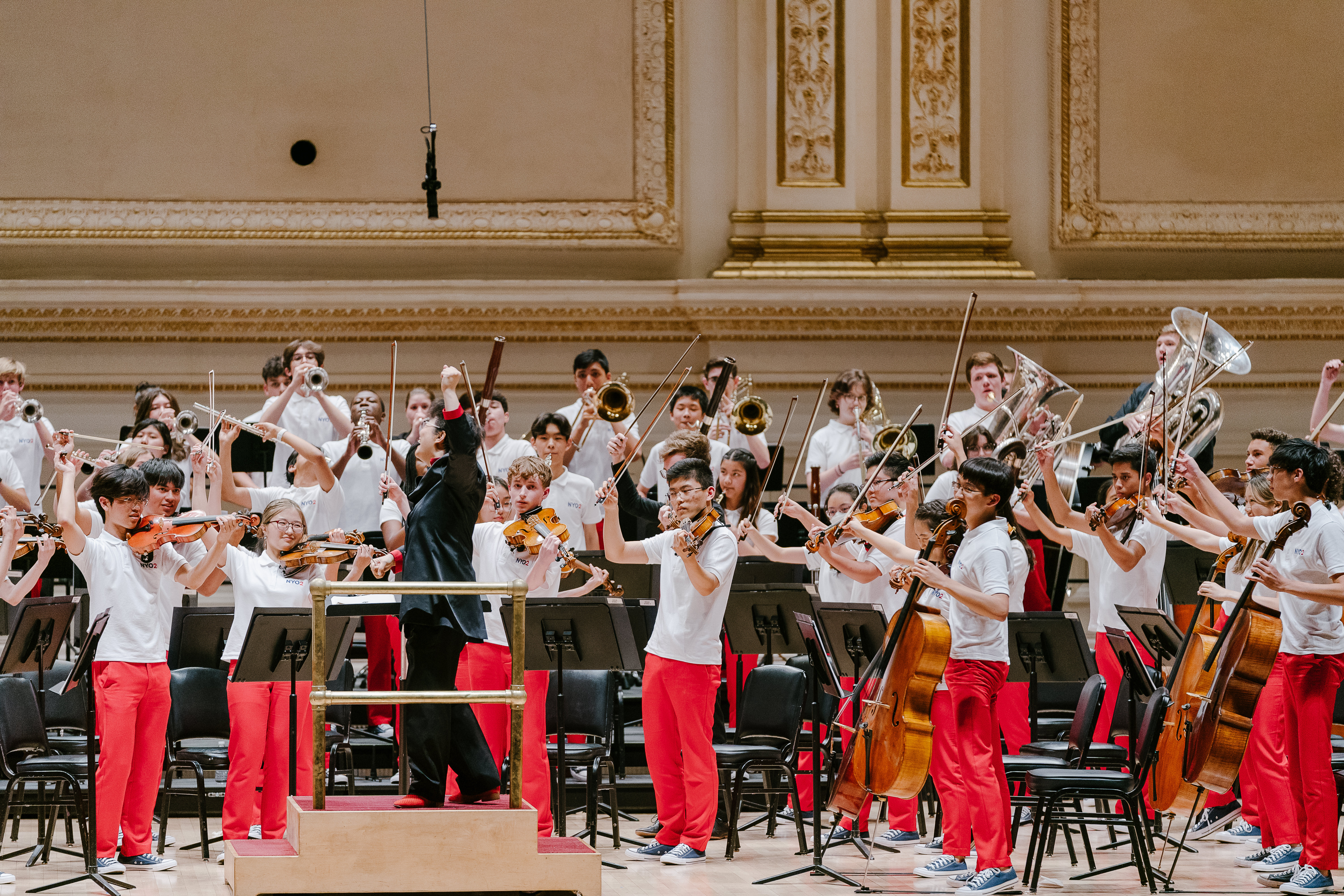 Orchestra of young people in red trousers, during a performance