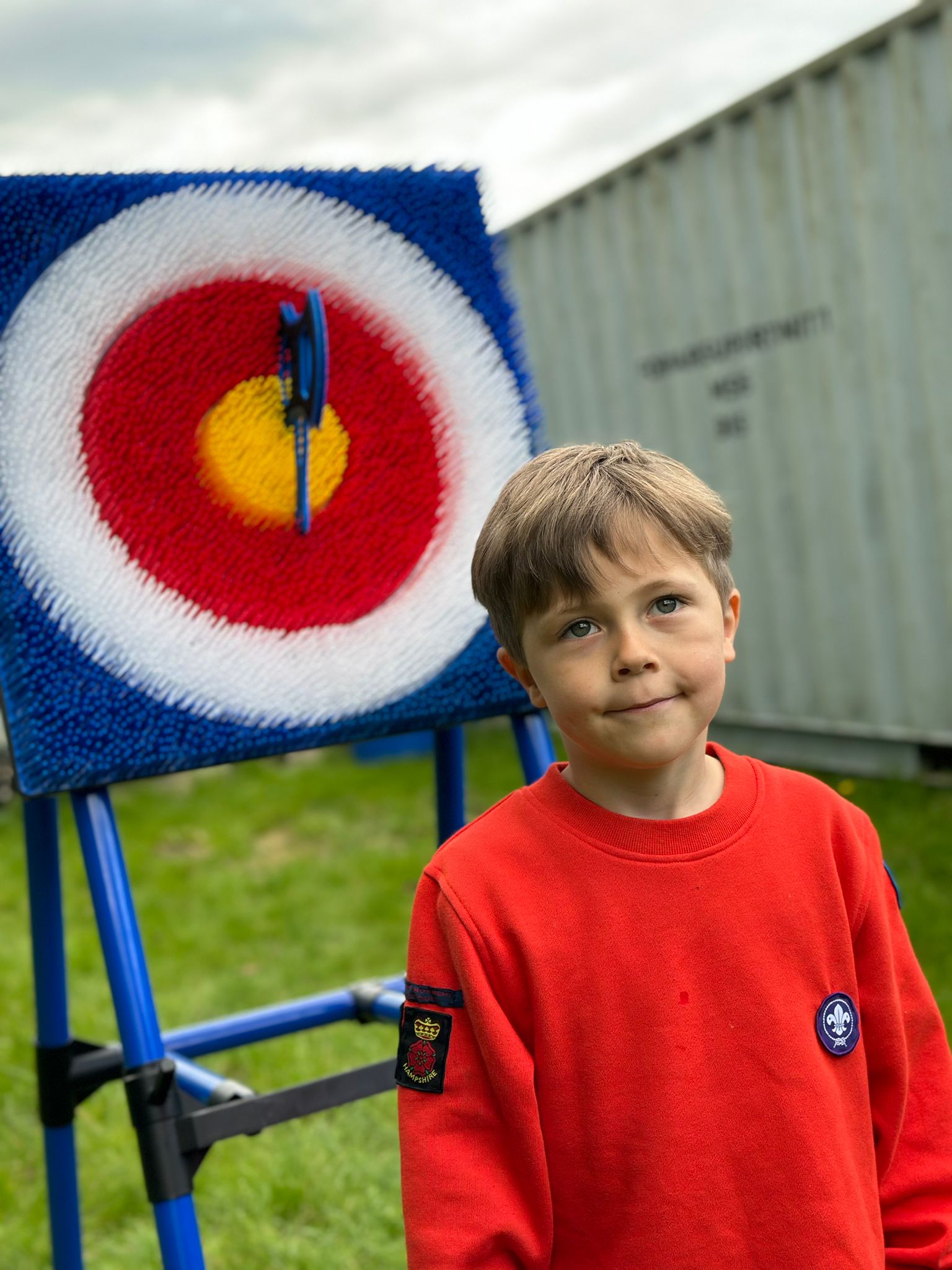 A boy standing in front of an archery target