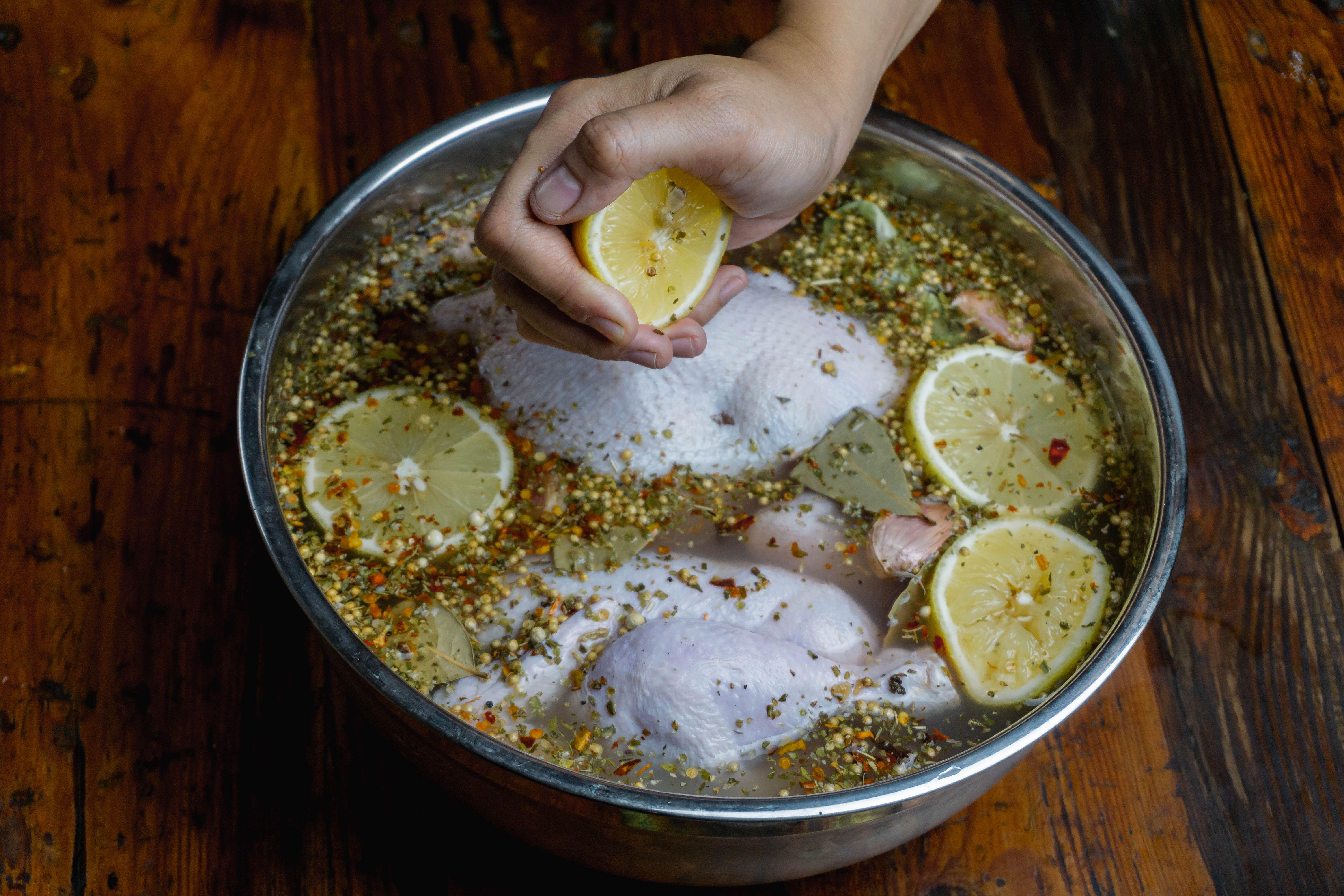 Squeezing lemon over turkey while brining