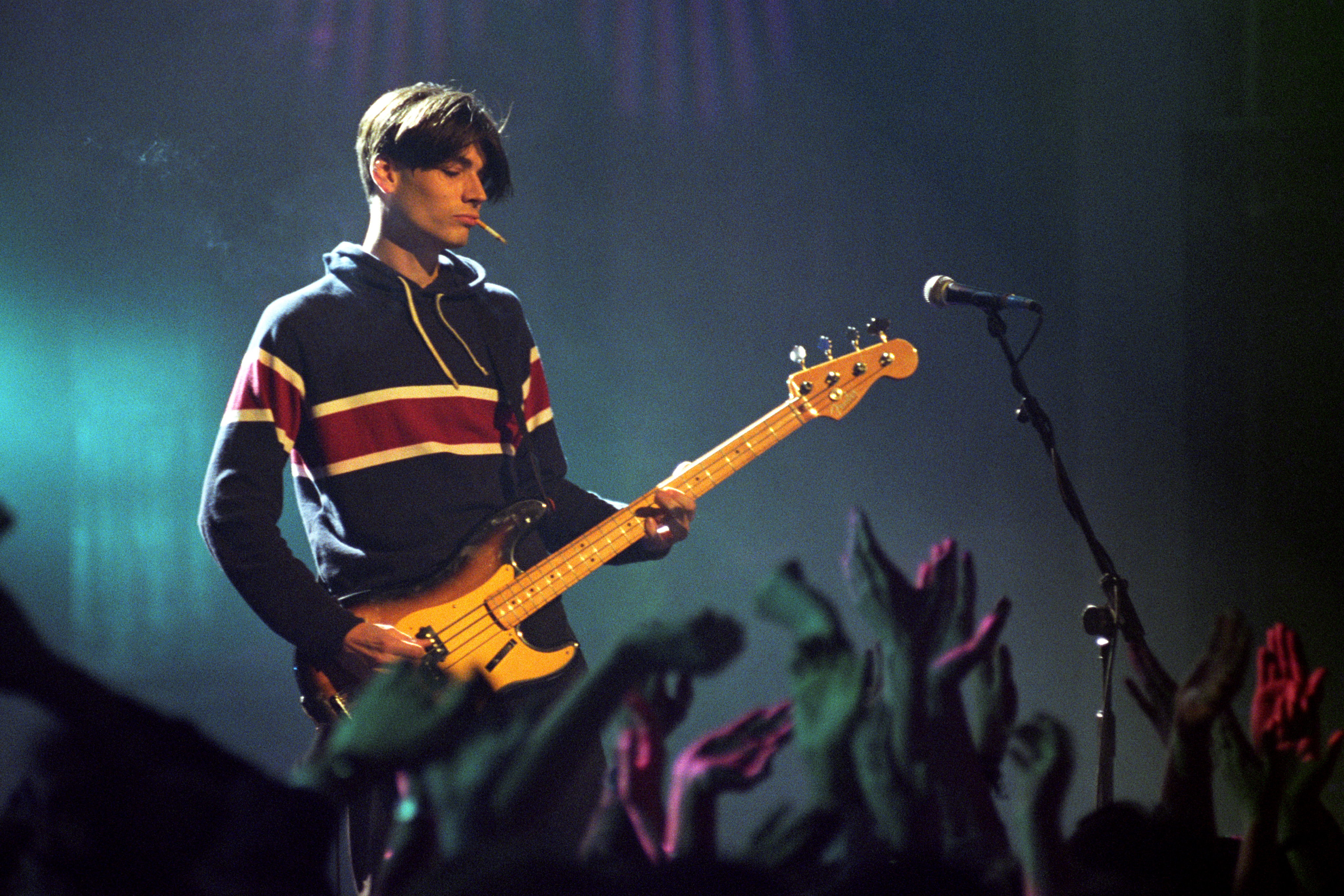 Blur bassist Alex James performing on stage at the 1995 Brit Awards.