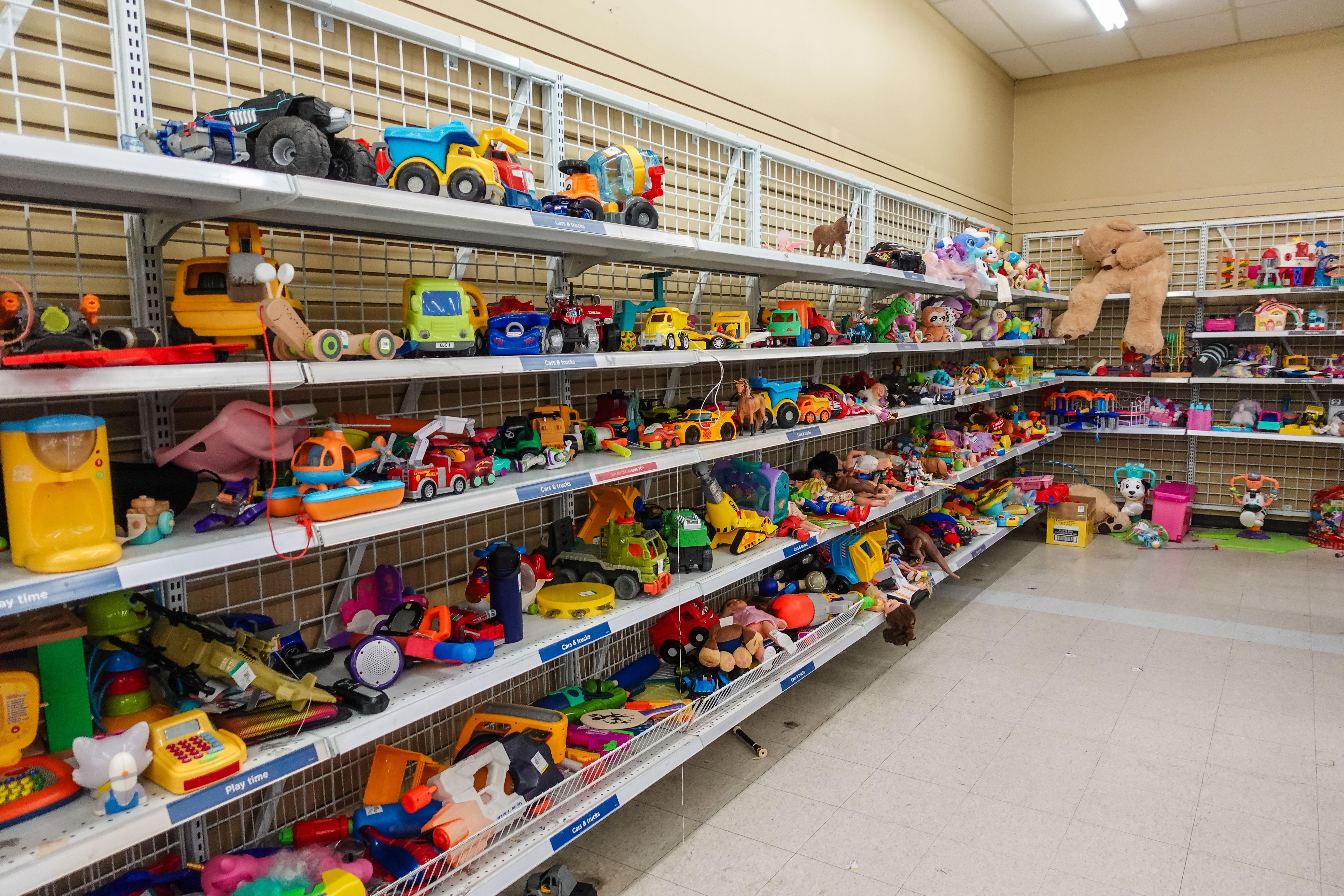 Second hand children toys sitting on shelves in a shop