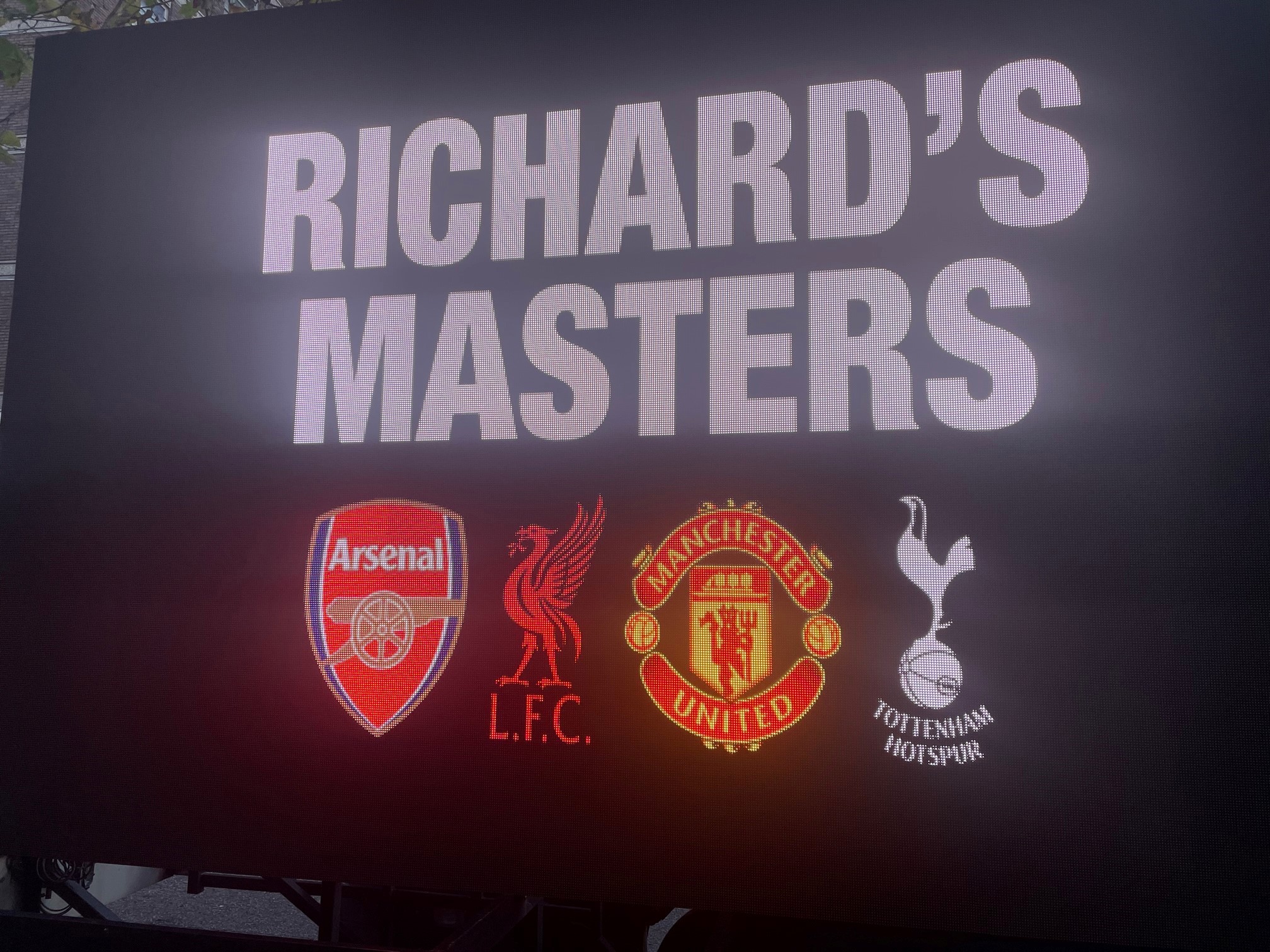 A digital display board on a van parked outside a Premier League shareholders meeting reads 'Richard's Masters' and bears the logos of Arsenal, Liverpool, Manchester United and Tottenham