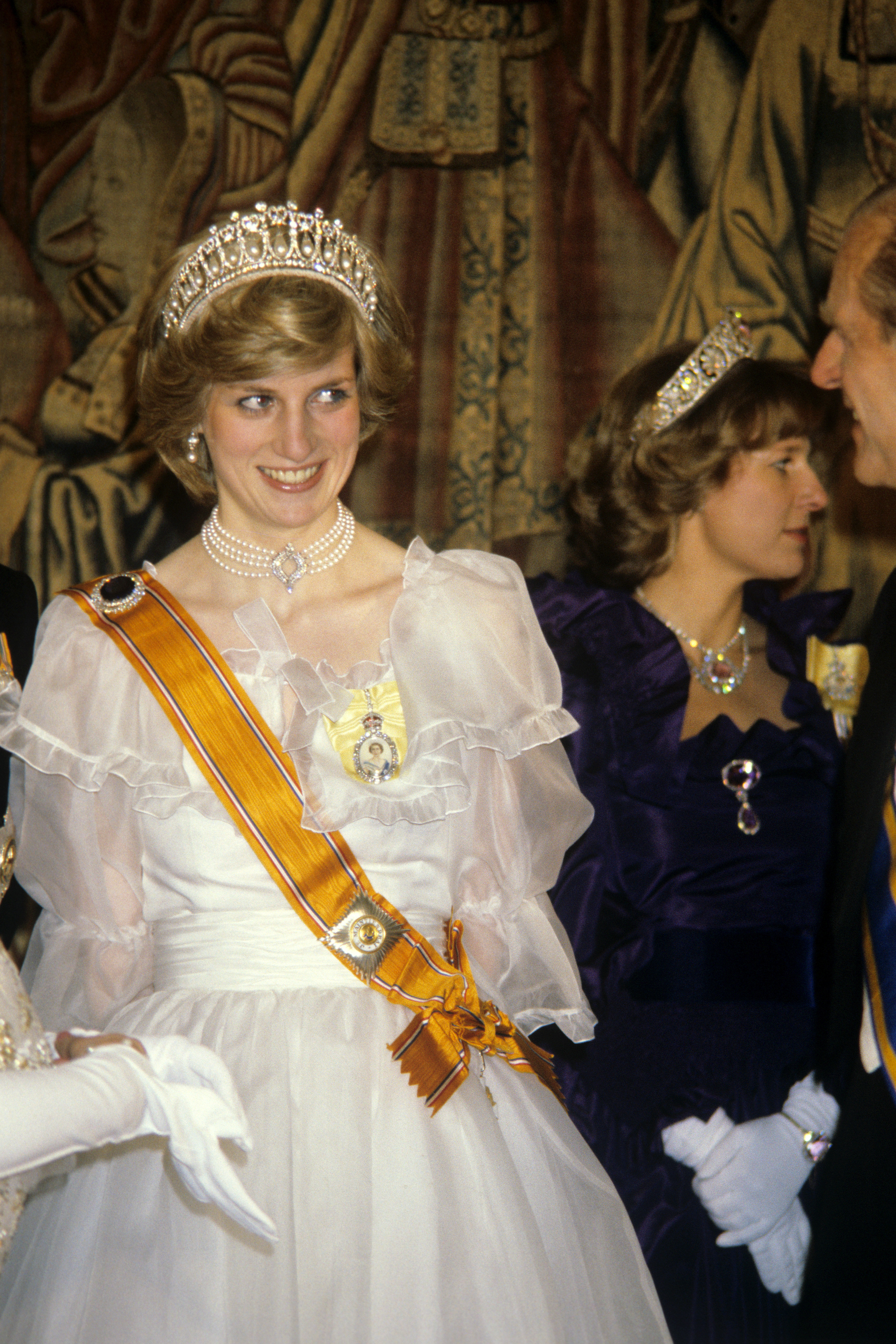 The Princess of Wales at a banquet for the British royal family given by Queen Beatrix and Prince Claus of the Netherlands at Hampton Court Palace. The Princess wears the sash of the House Order of Orange, presented to her by Queen Beatrix.