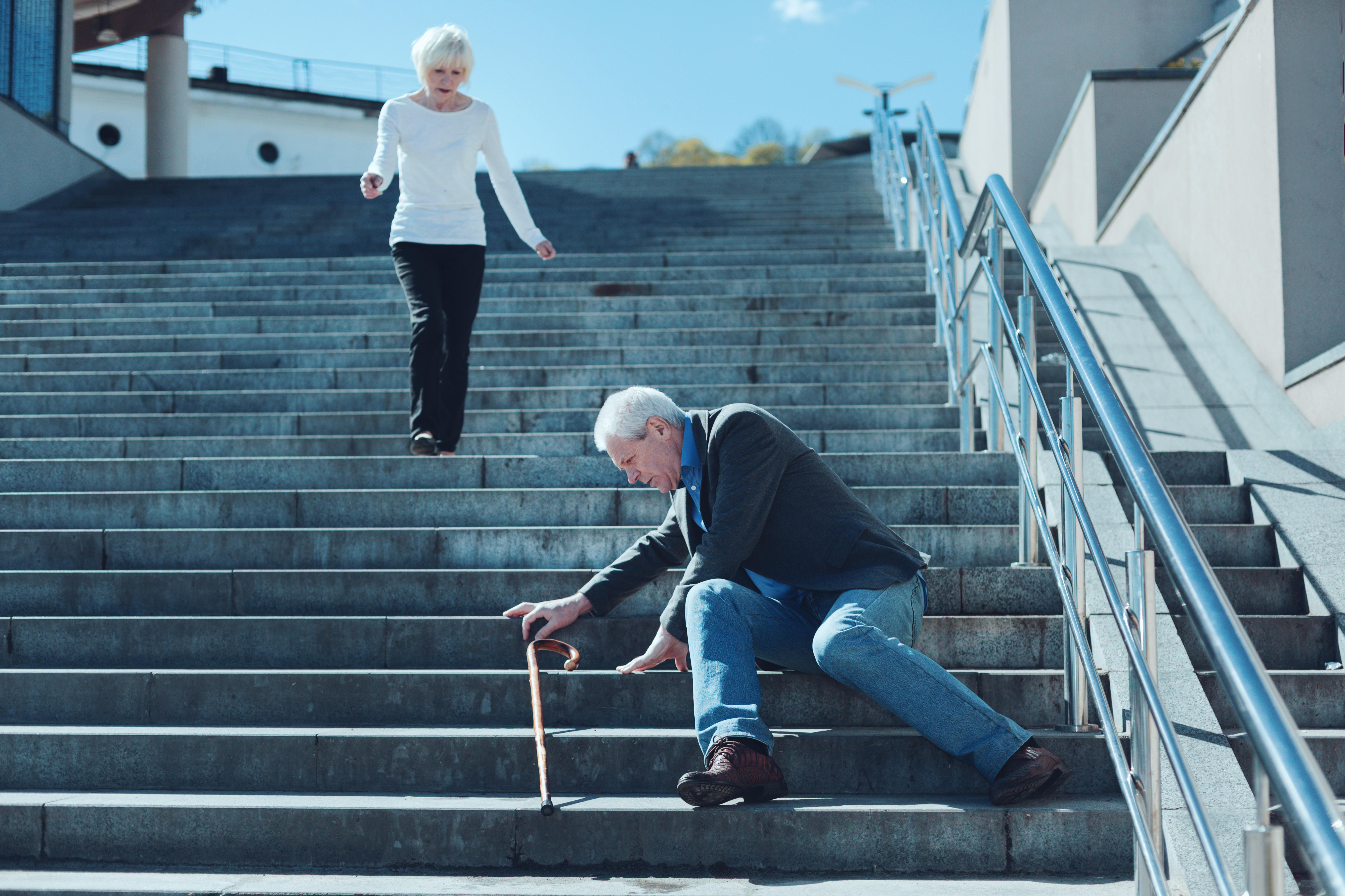 A woman running down some steps to look after her husband who has fallen over