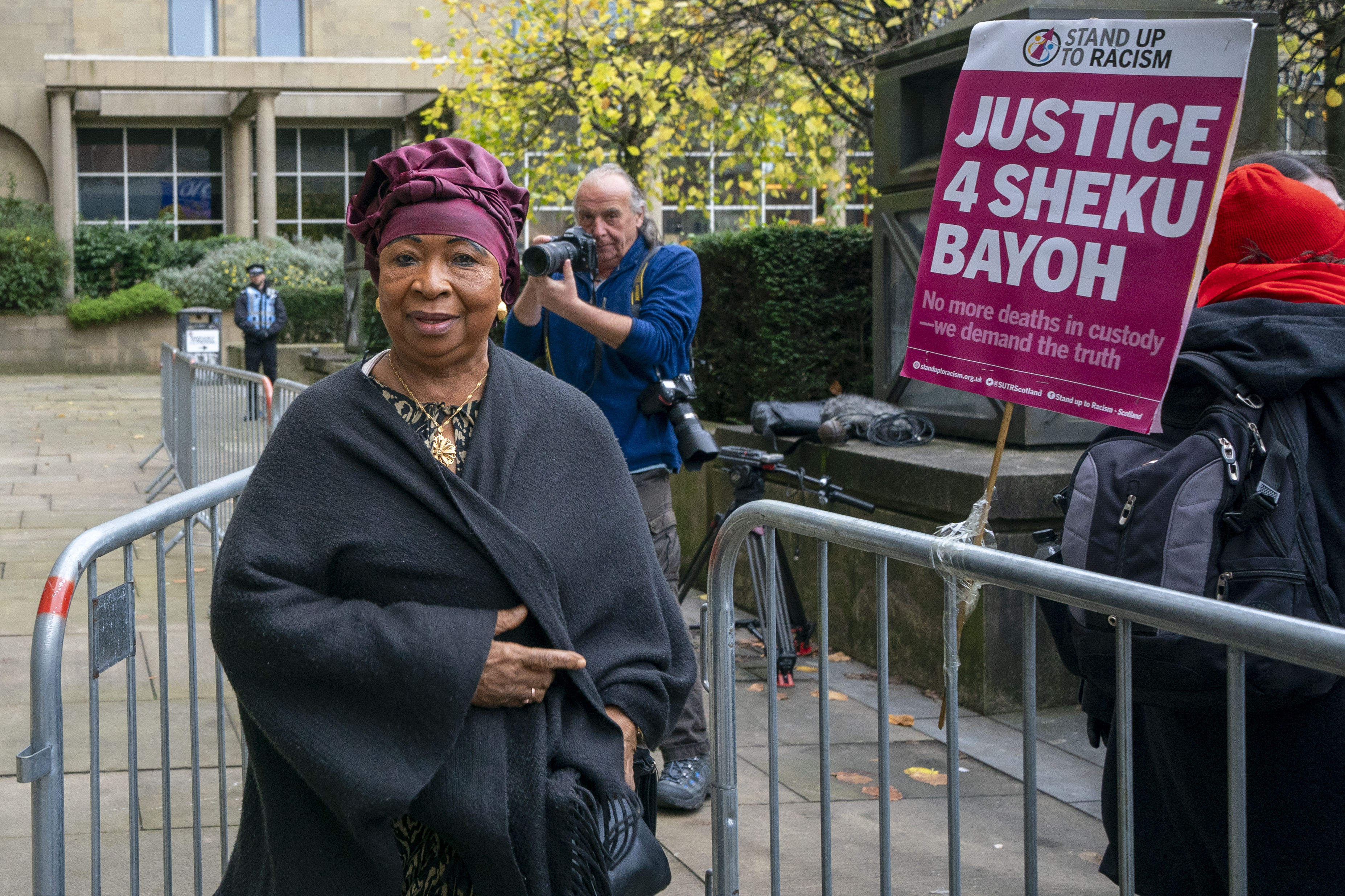 Aminata Bayoh beside a placard reading 'Justice 4 Sheku Bayoh'