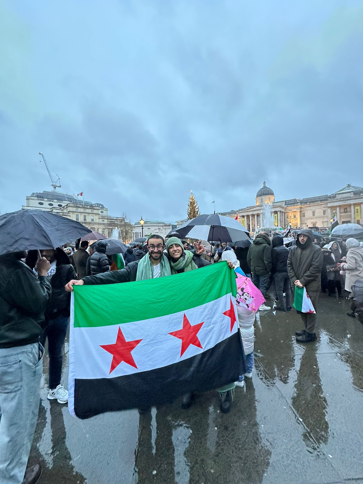 Two people smiling with a flag