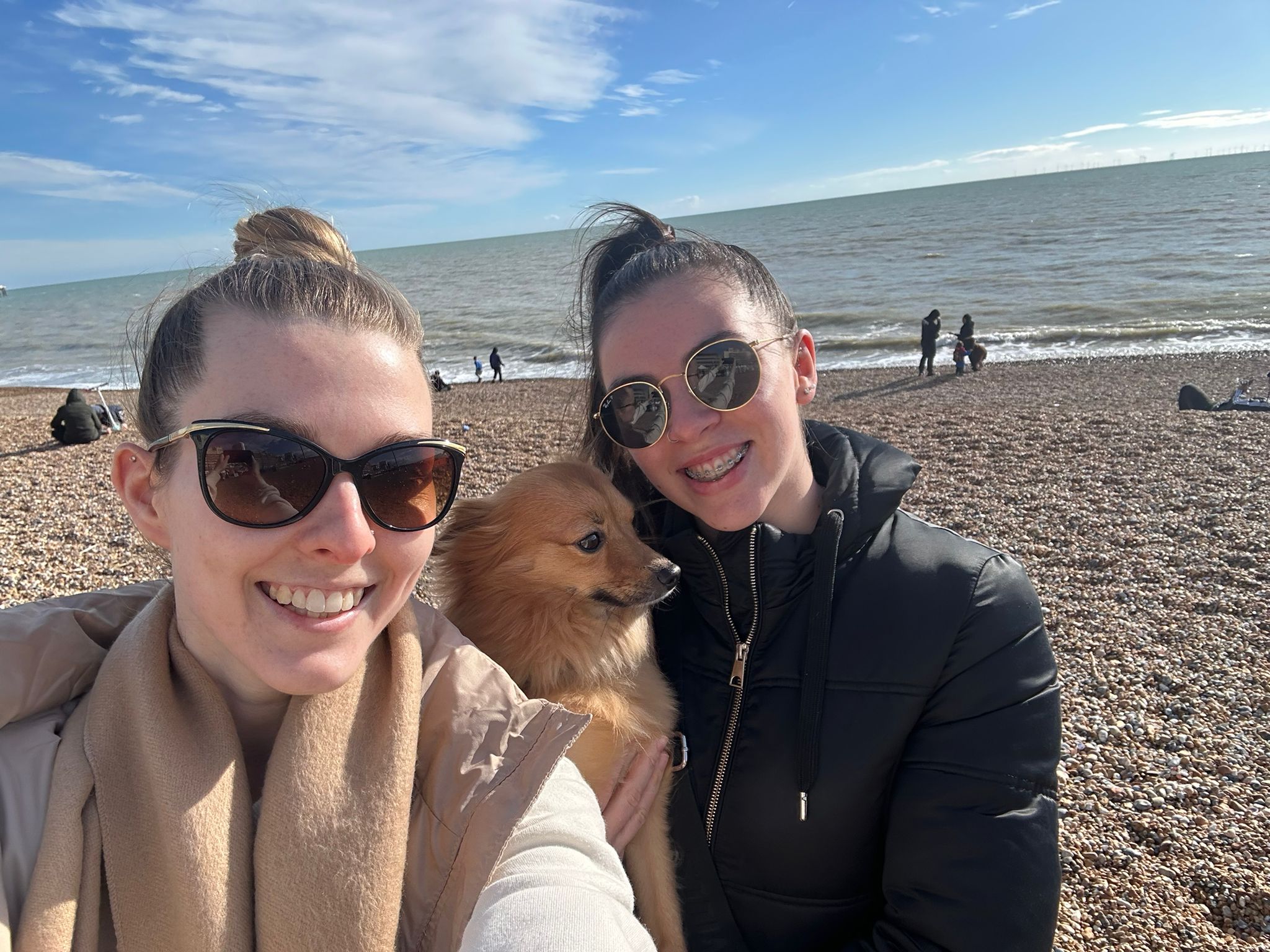 Two women smiling with a dog