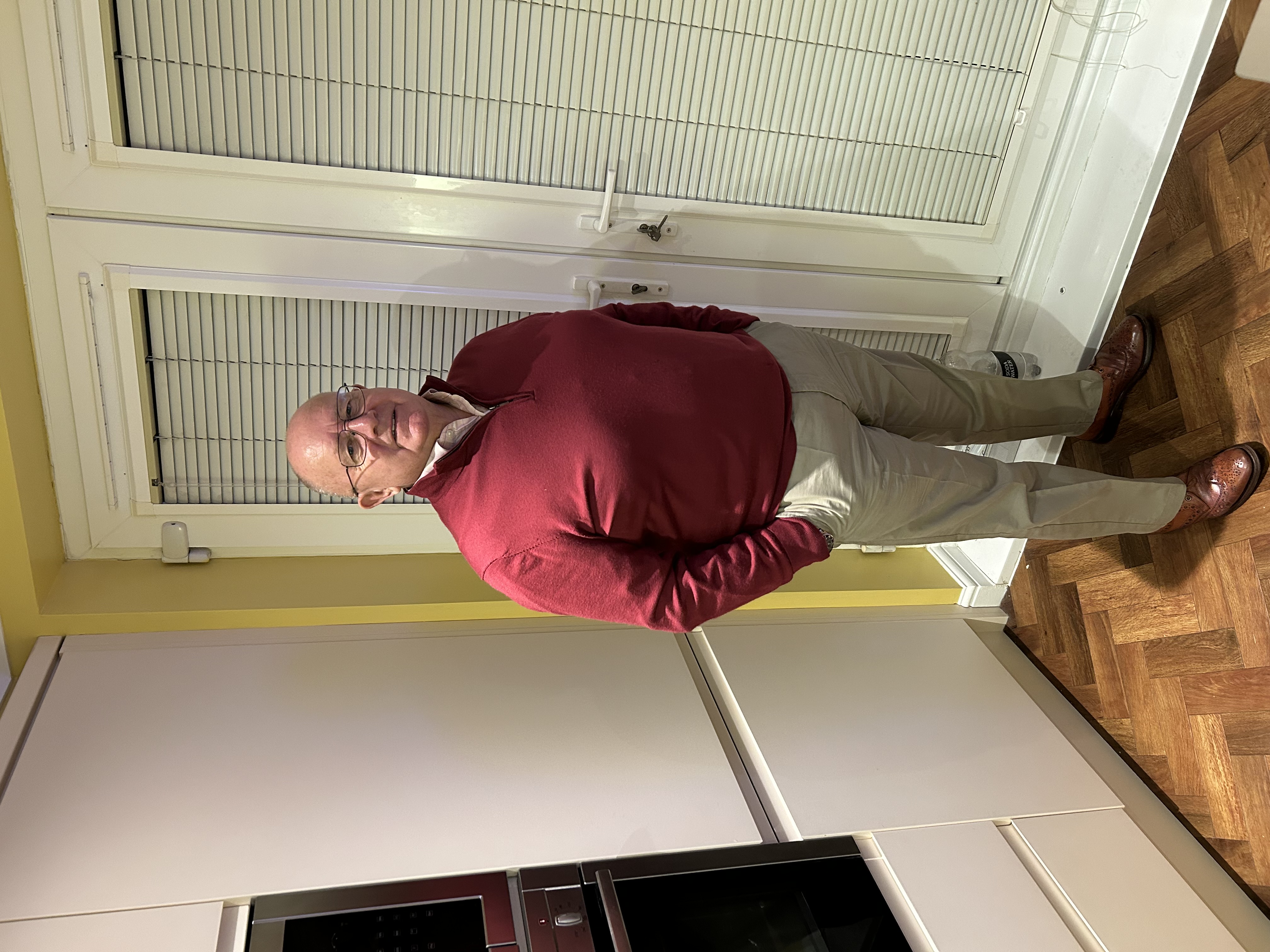 John Pengelly standing and wearing a red jumper