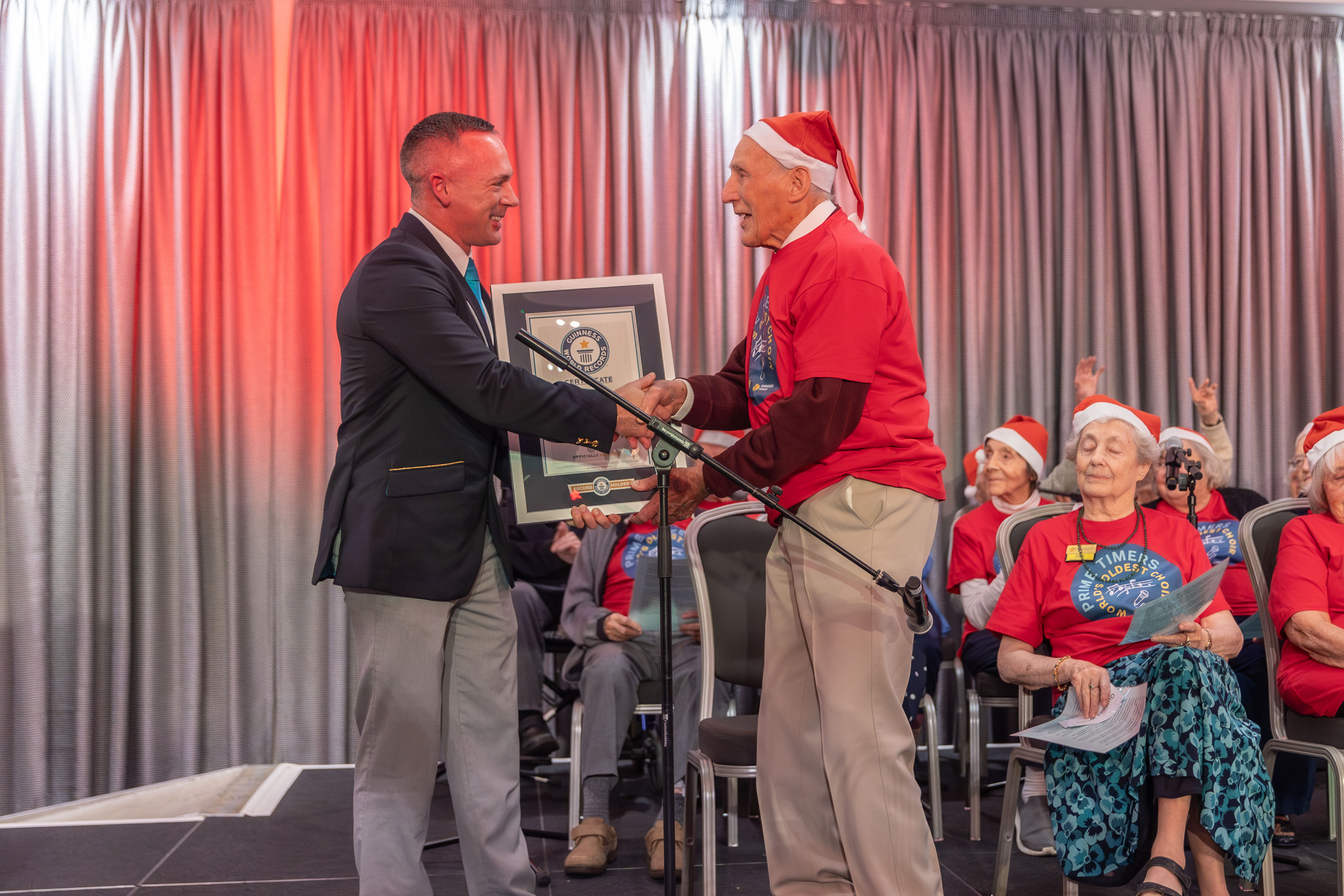 Elderly man dressed in Santa hat receives Guinness World Record certificate