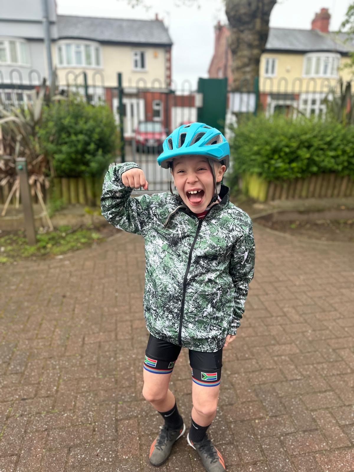 Harvey wearing his cycling gear and pumping a fist in the air