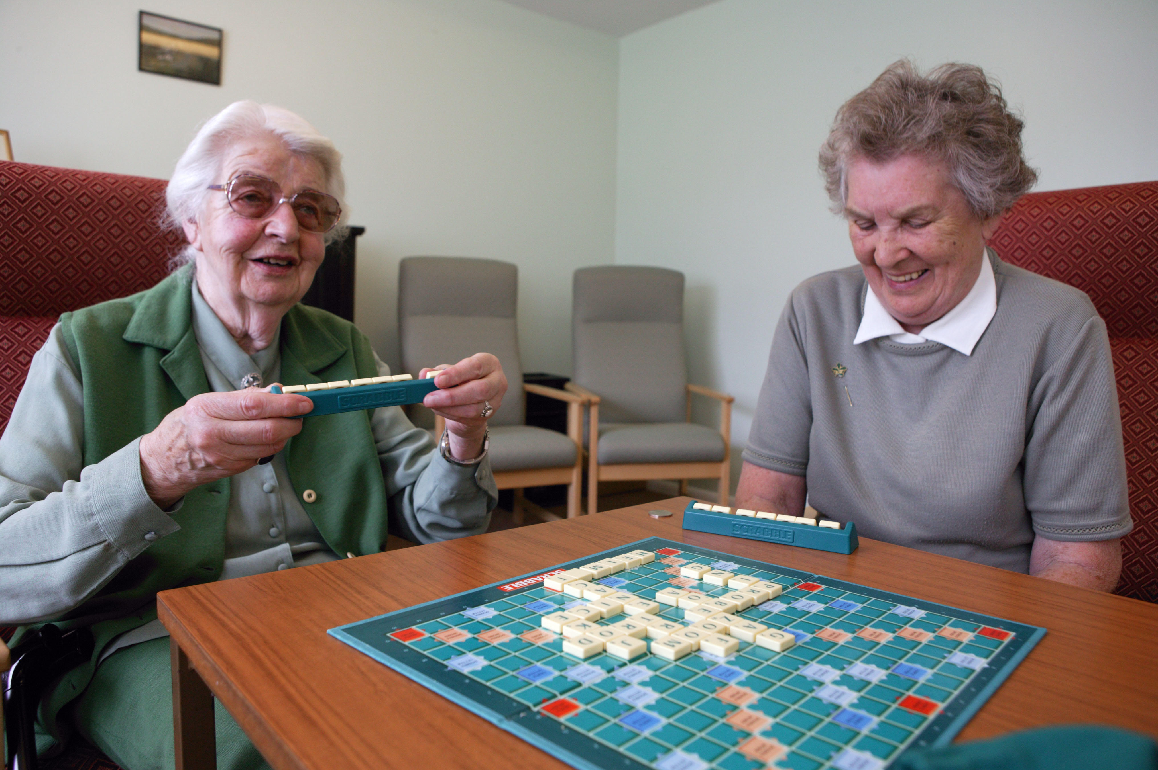 Two elderly women playing game of scrabble 