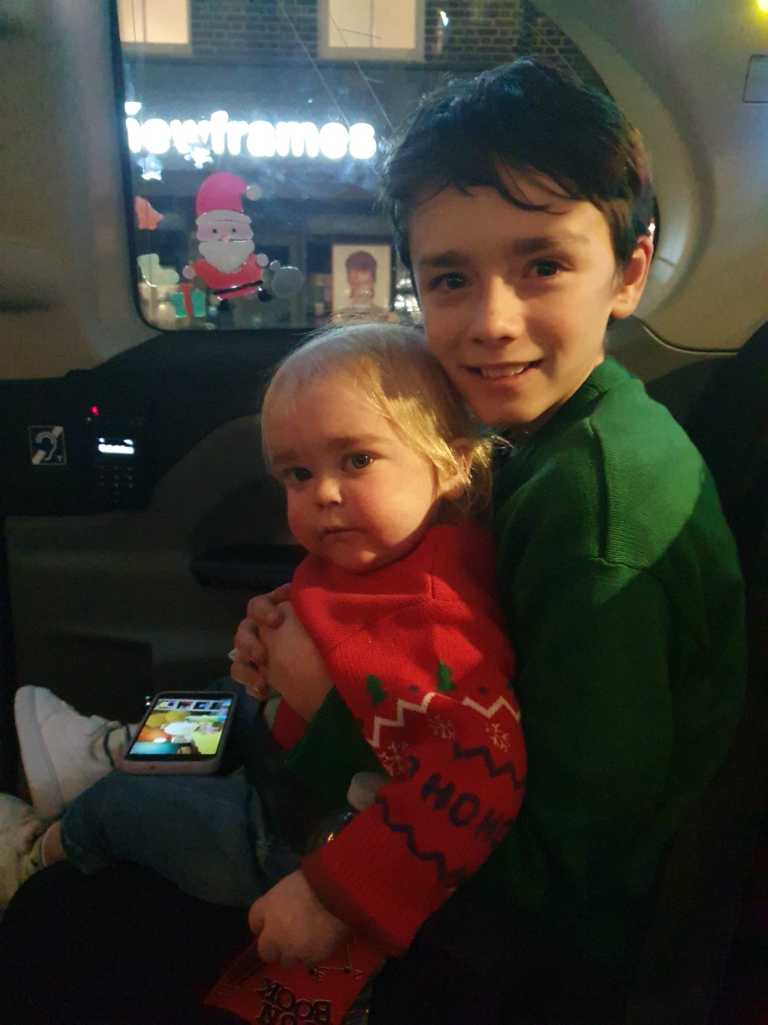 Alfie sitting on brother Teddie's knee in the black cab