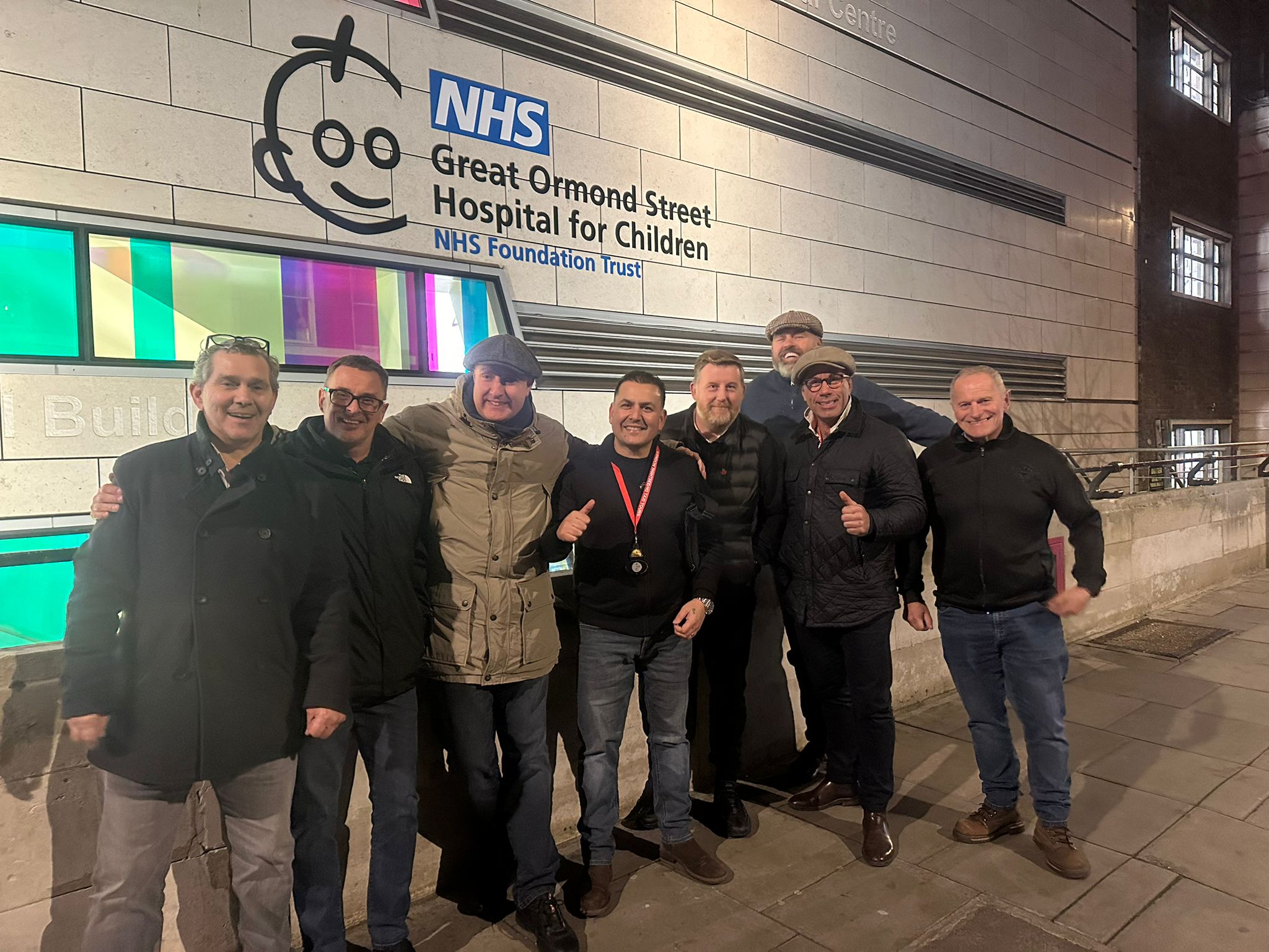 The eight black cab drivers who offered free festive lights tours stood outside Great Ormond Street Hospital