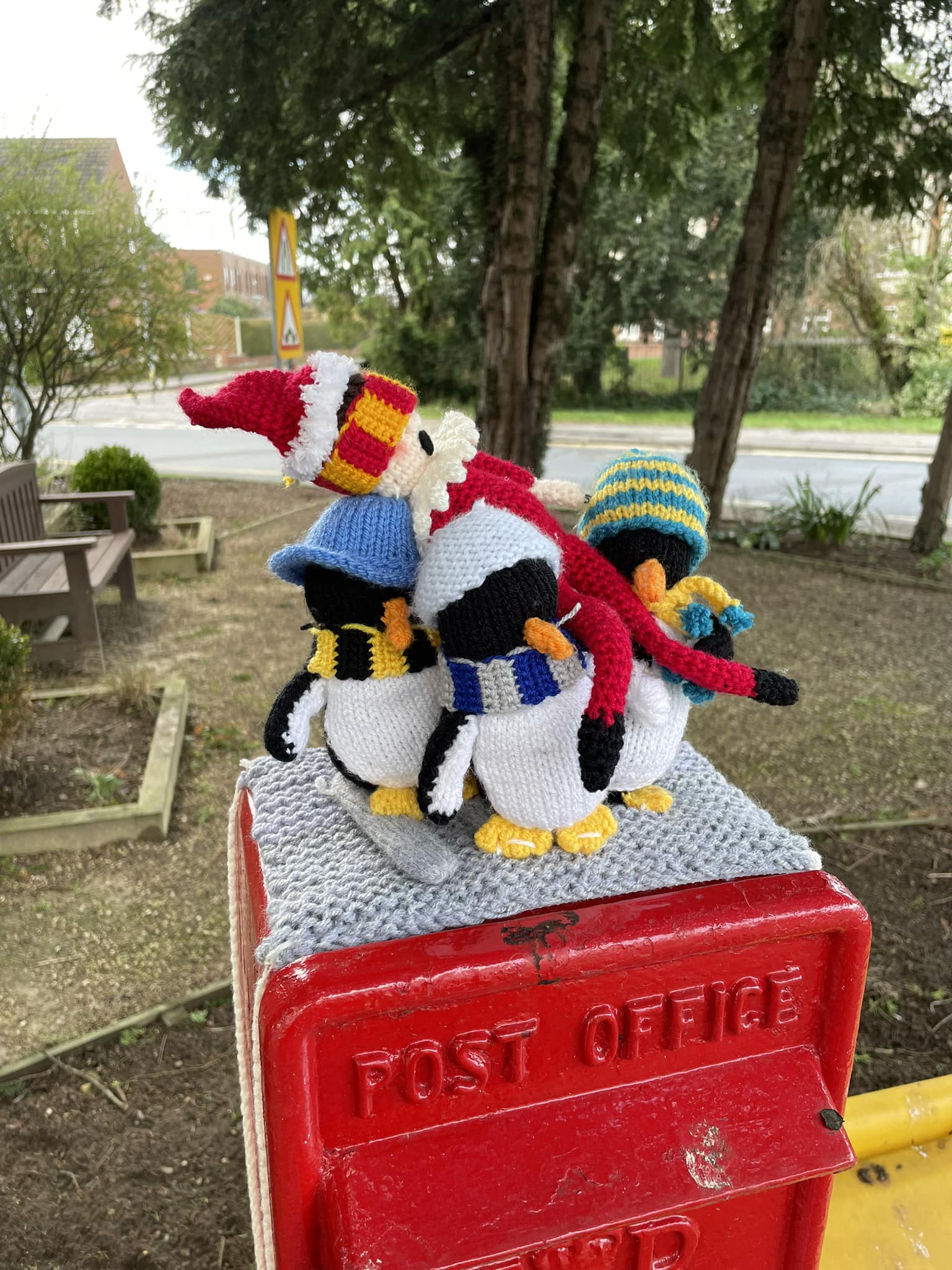 Crocheted penguins carrying crocheted elf 