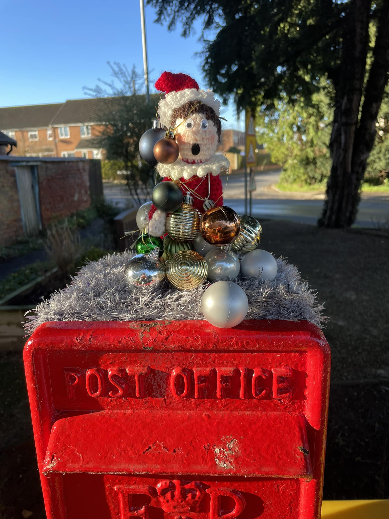 Crocheted elf wrapped in decorations 