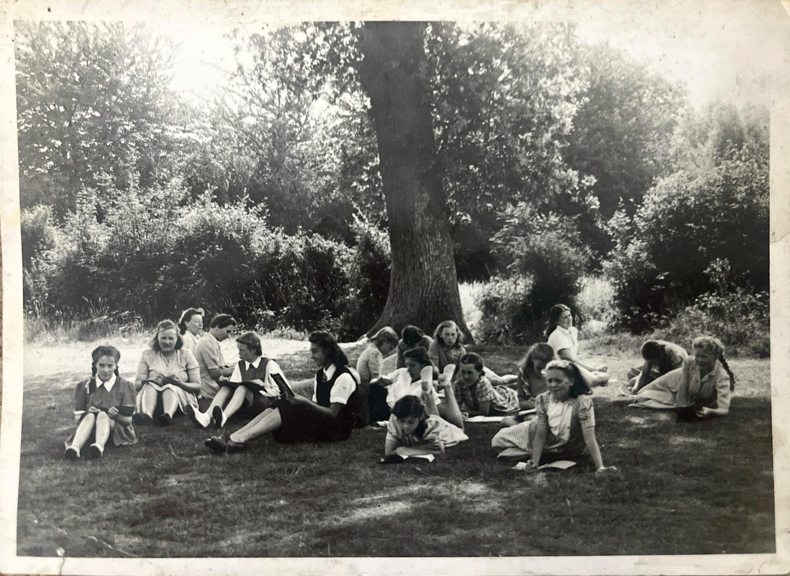 Black and white image of a group of schoolgirls under a tree