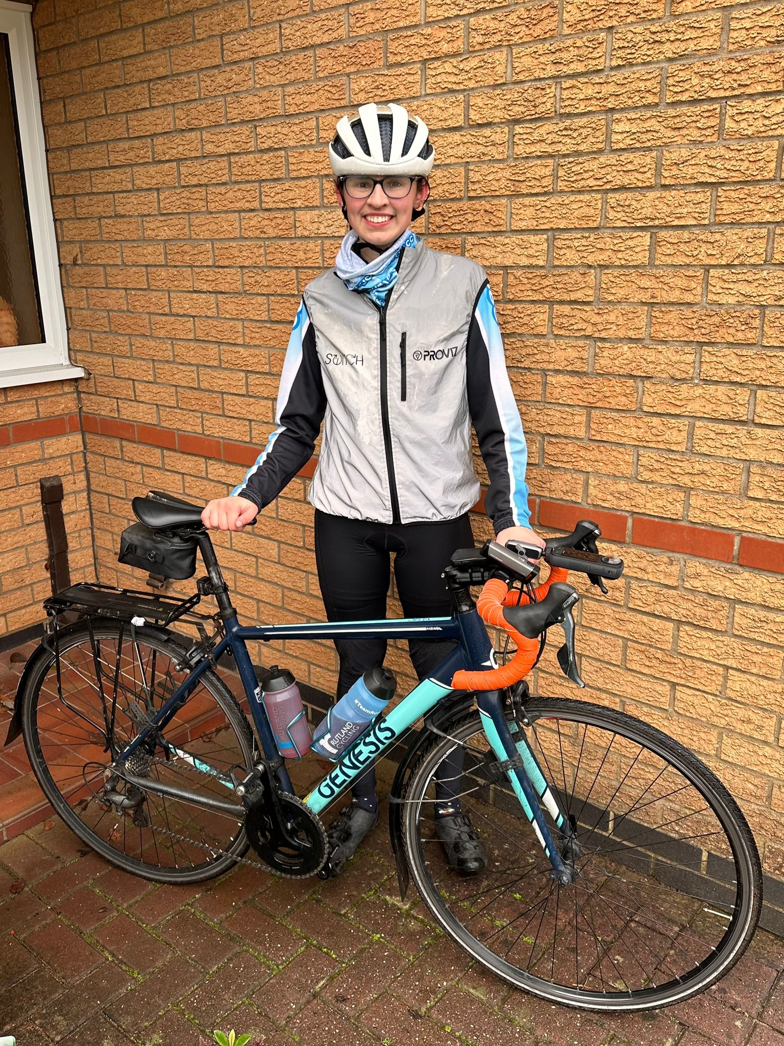 A girl smiling with a bicyle