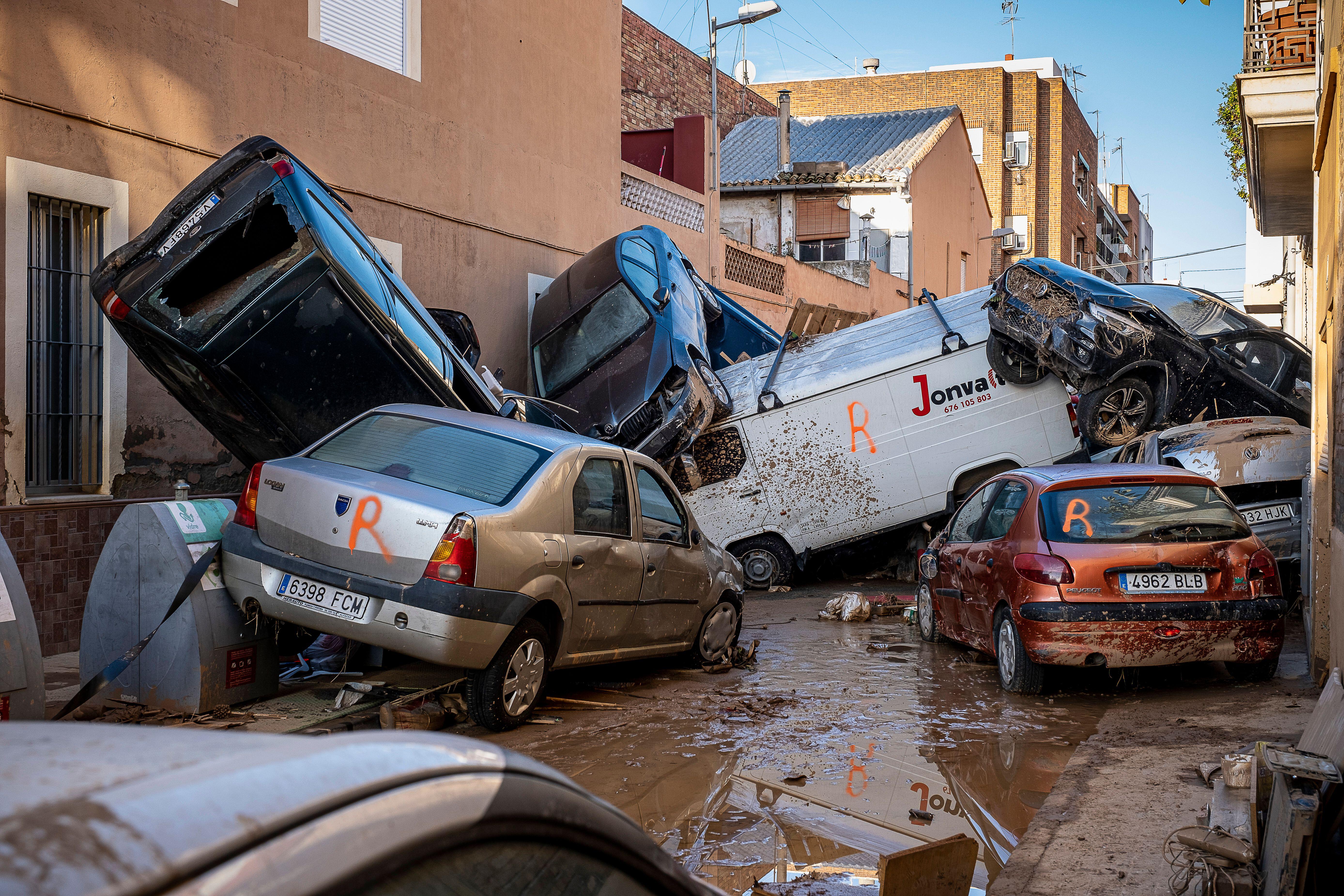 Cars piled up in a muddy street after the devastating flooding in Valencia 