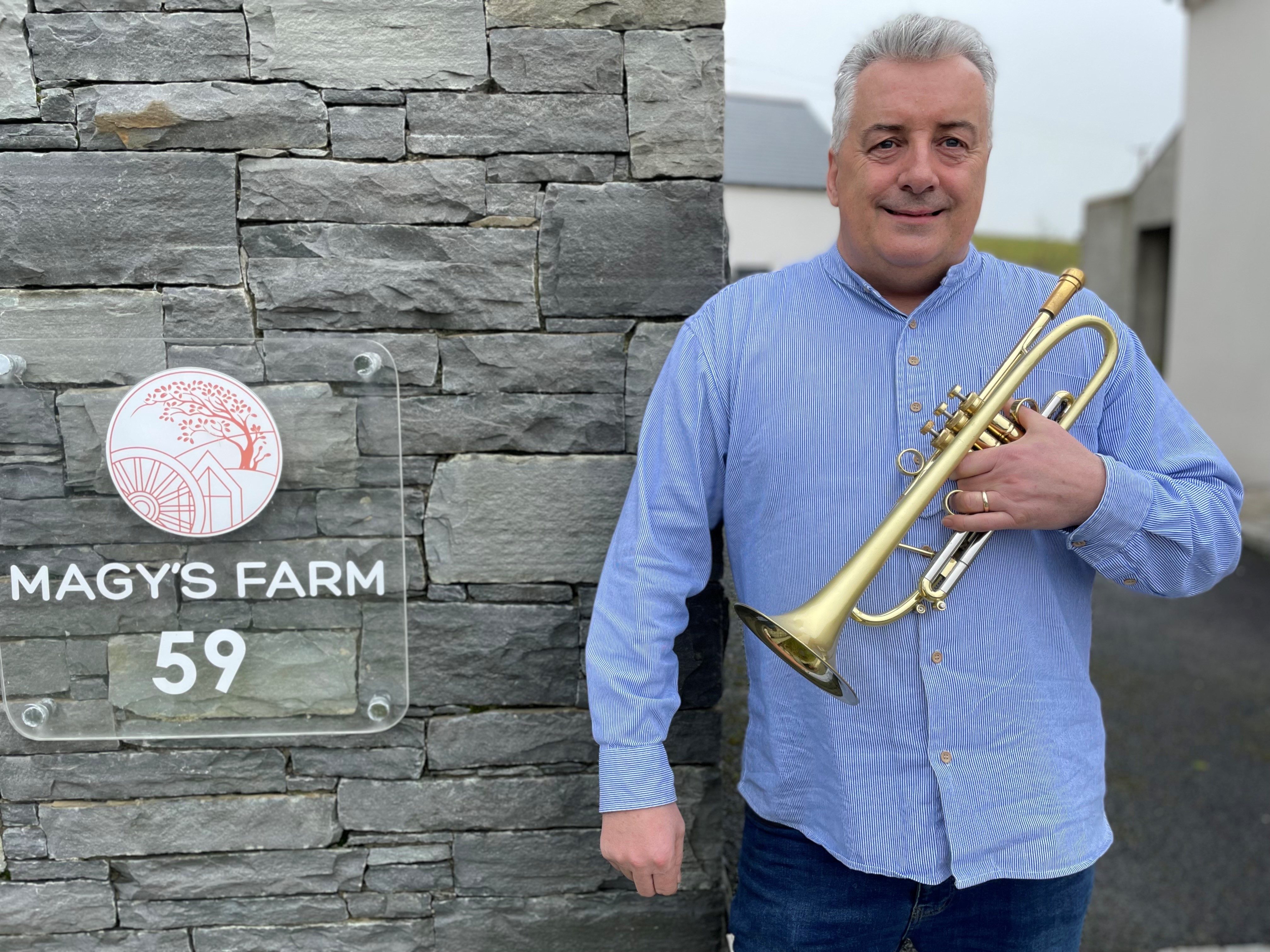 Linley Hamilton holds a trumpet at his Magy's Farm venue