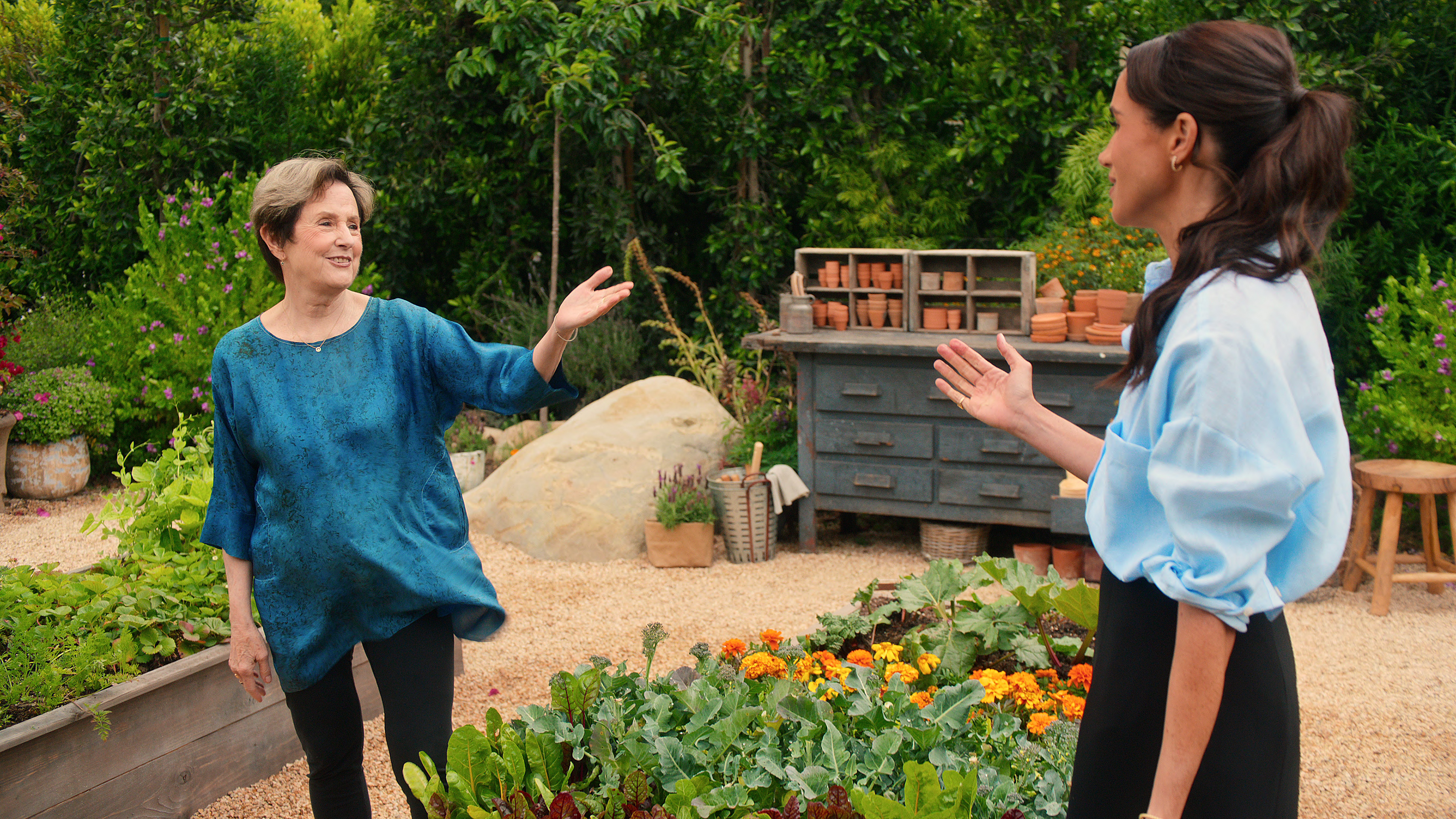 Alice Waters with Meghan in a garden in an episode from the show 