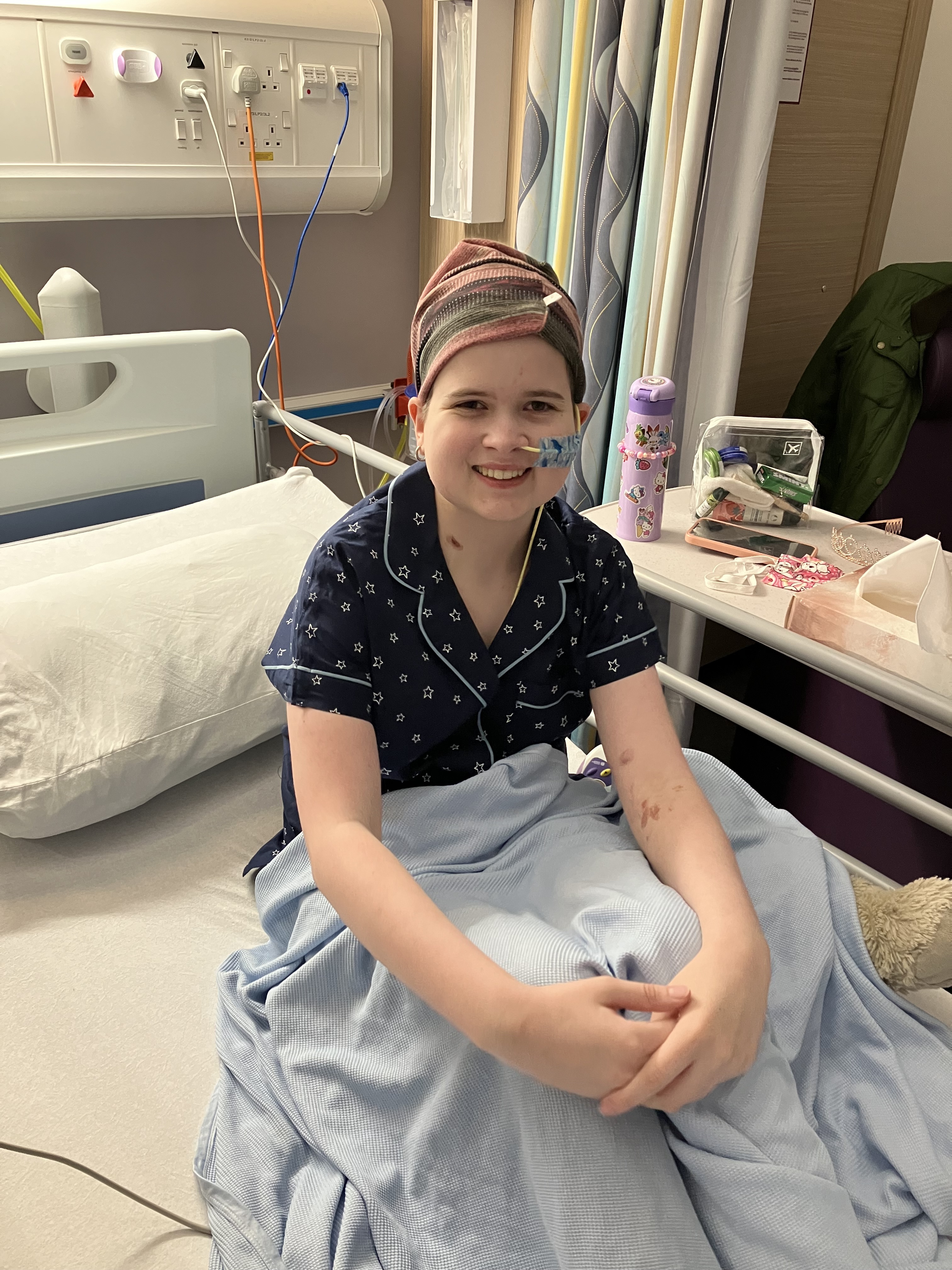 A young girl sitting on a hospital bed