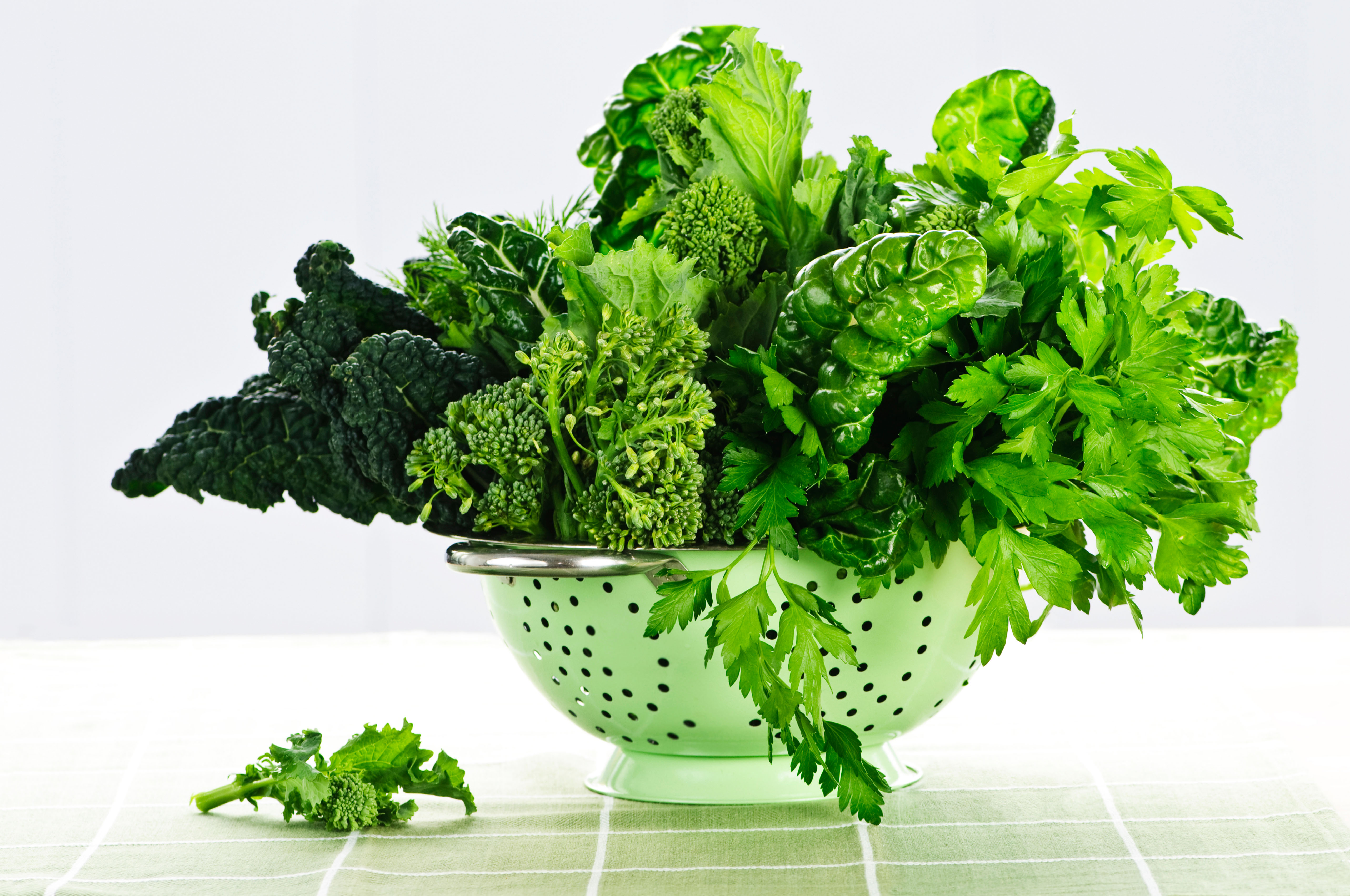 Dark green leafy fresh vegetables in a metal colander