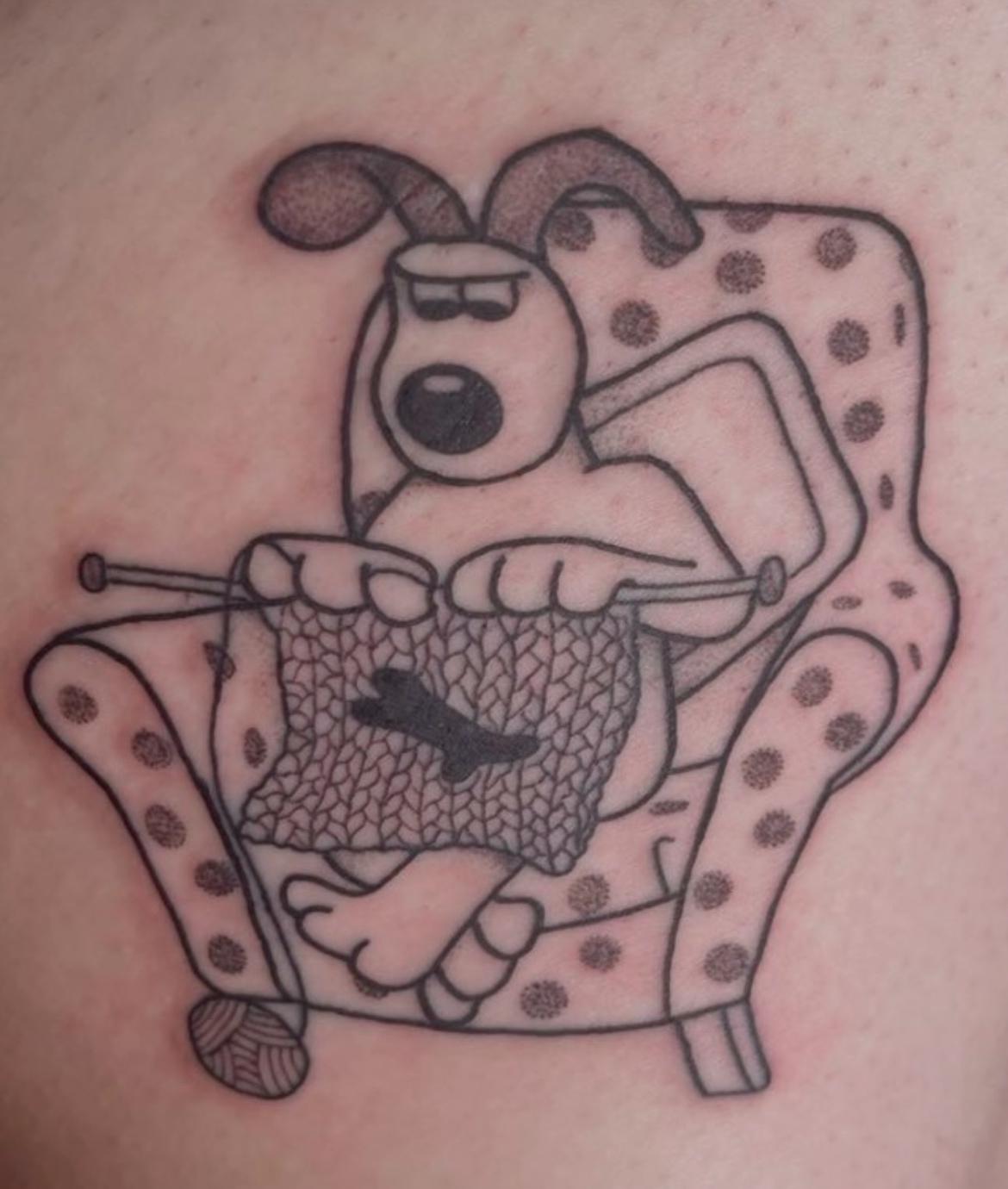 Tattoo of a dog knitting while sitting on chair