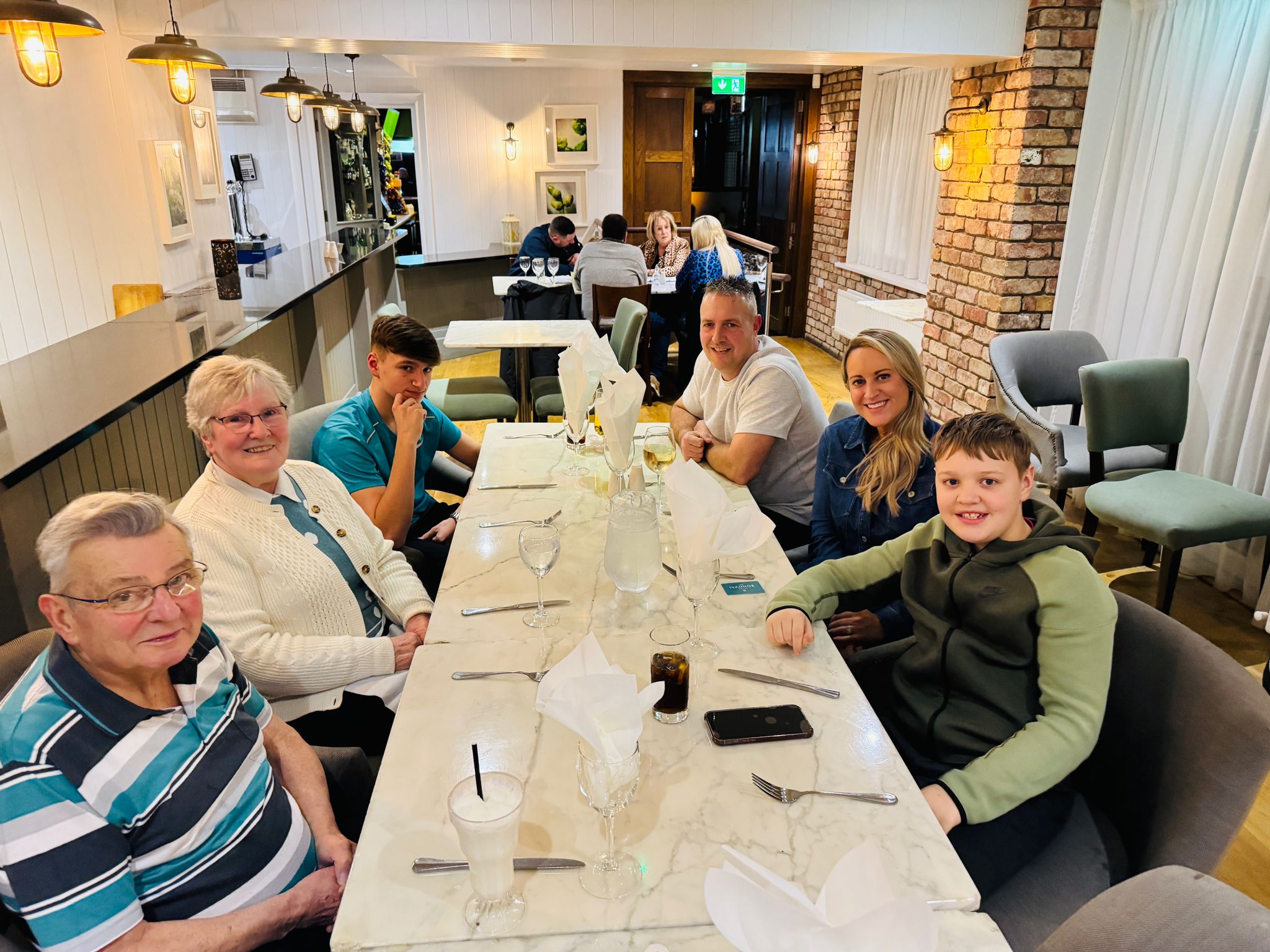 Family of six sitting at a dining table at a restaurant