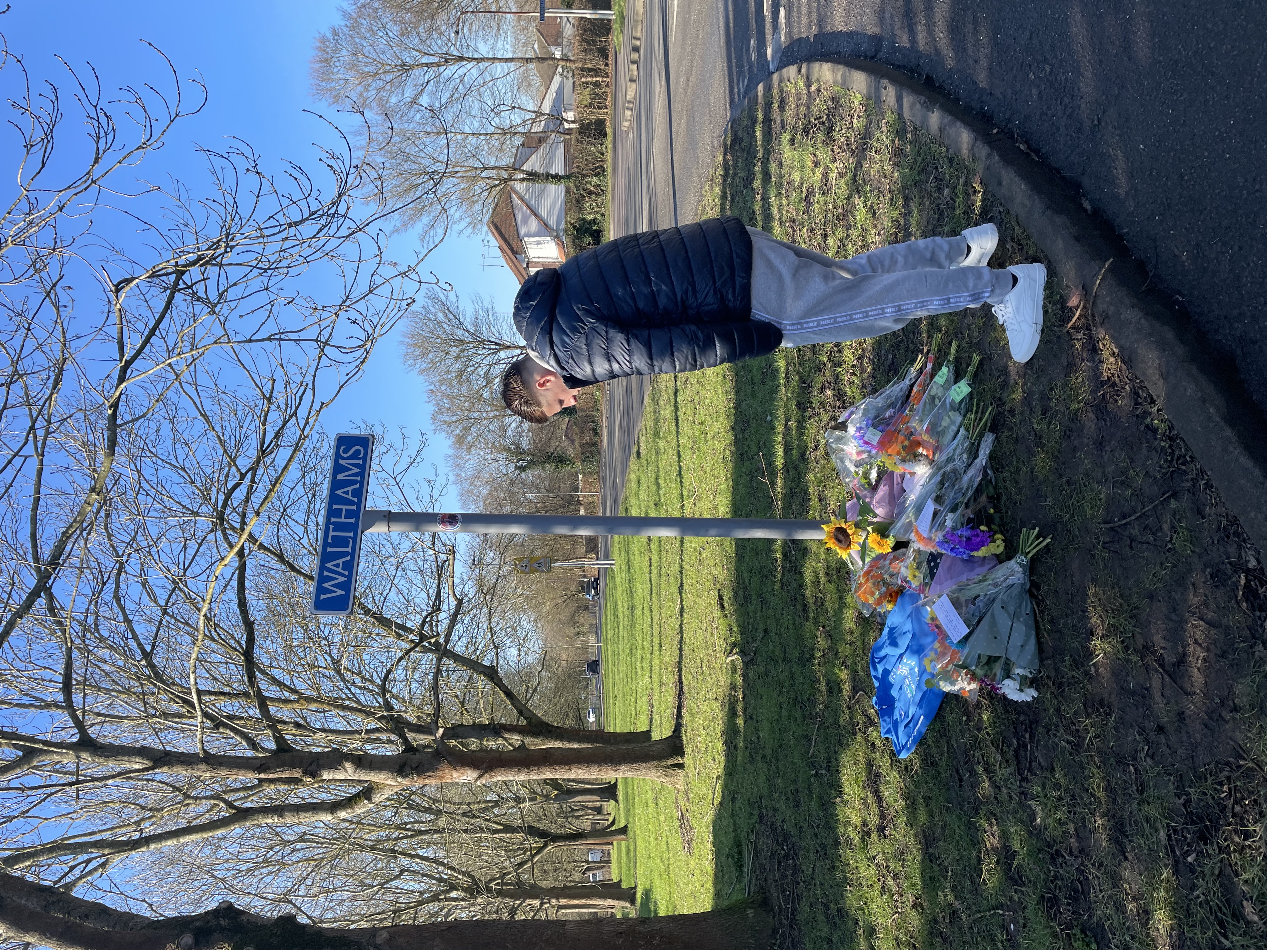 A man leaves flowers at the site of a hit and run crash in Essex