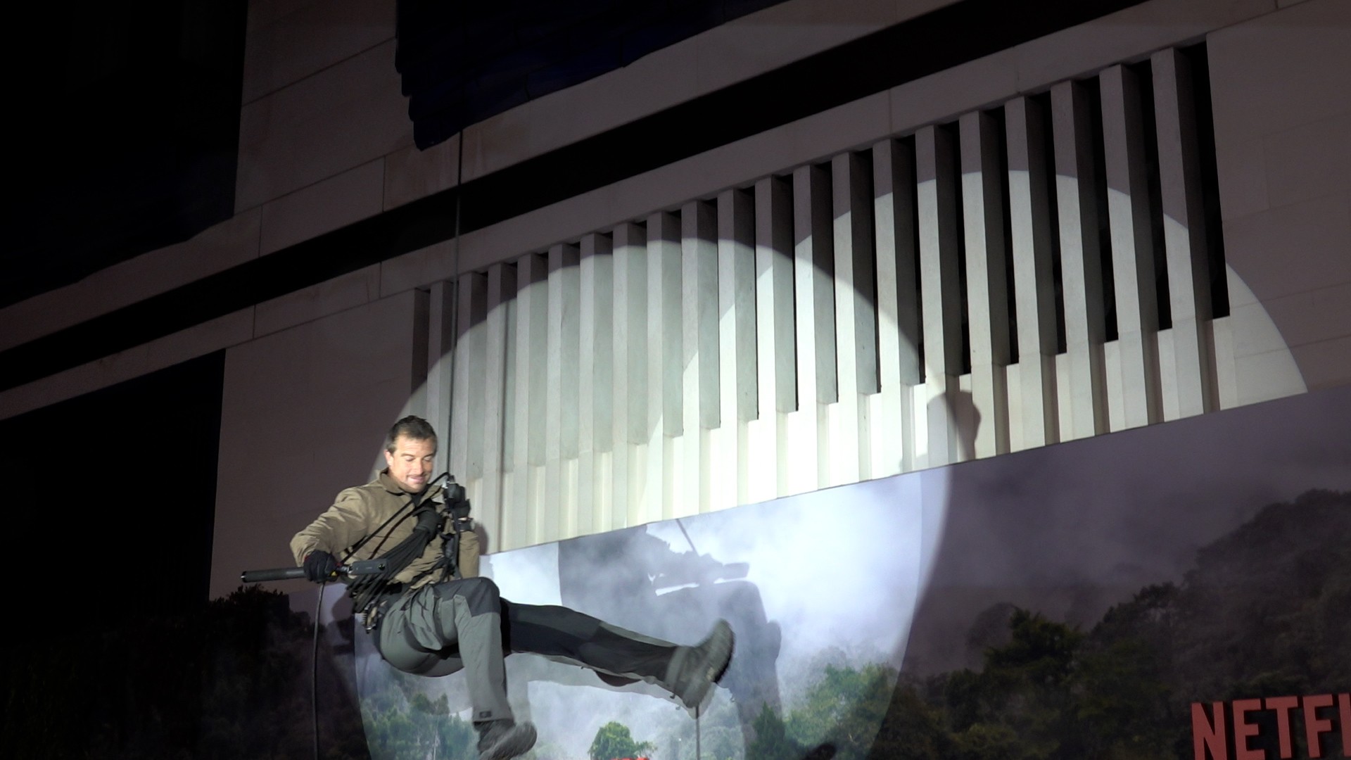 Bear Grylls in a spotlight as he abseils down a building