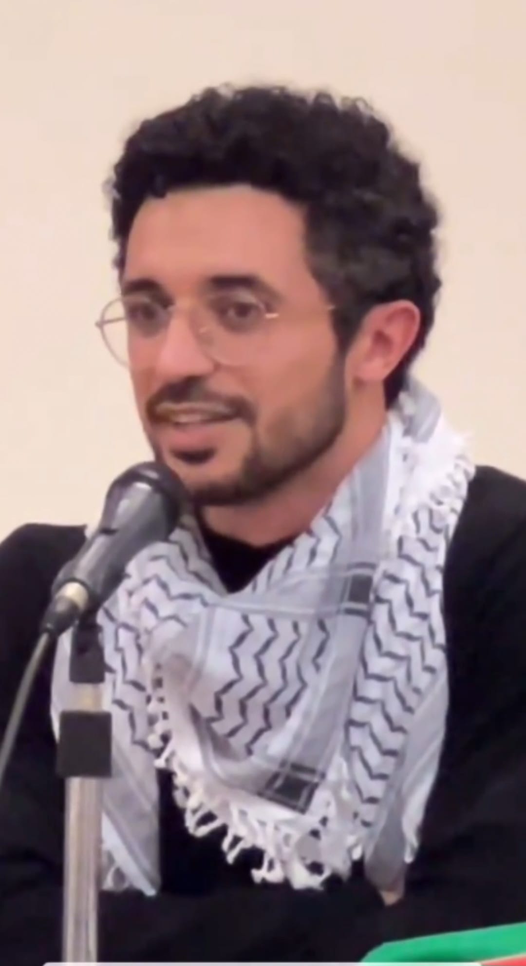 A man wearing a keffiyeh scarf