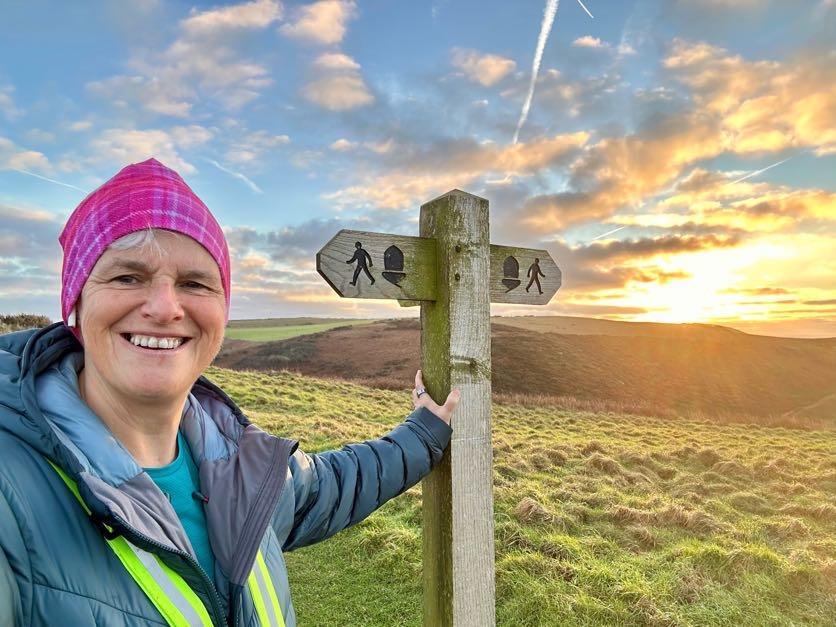 A woman beside a signpost