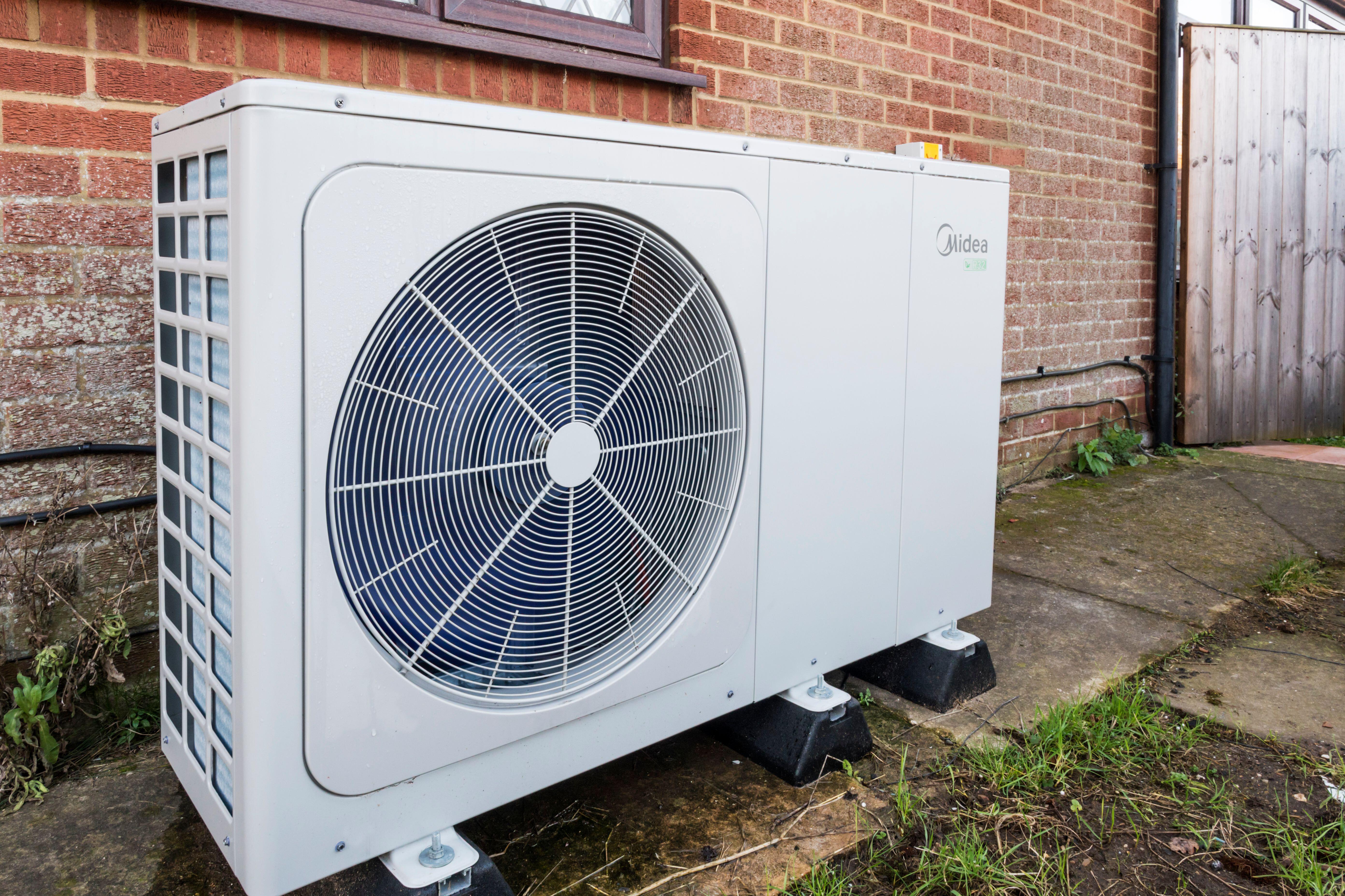 A heat pump outside a brick house 