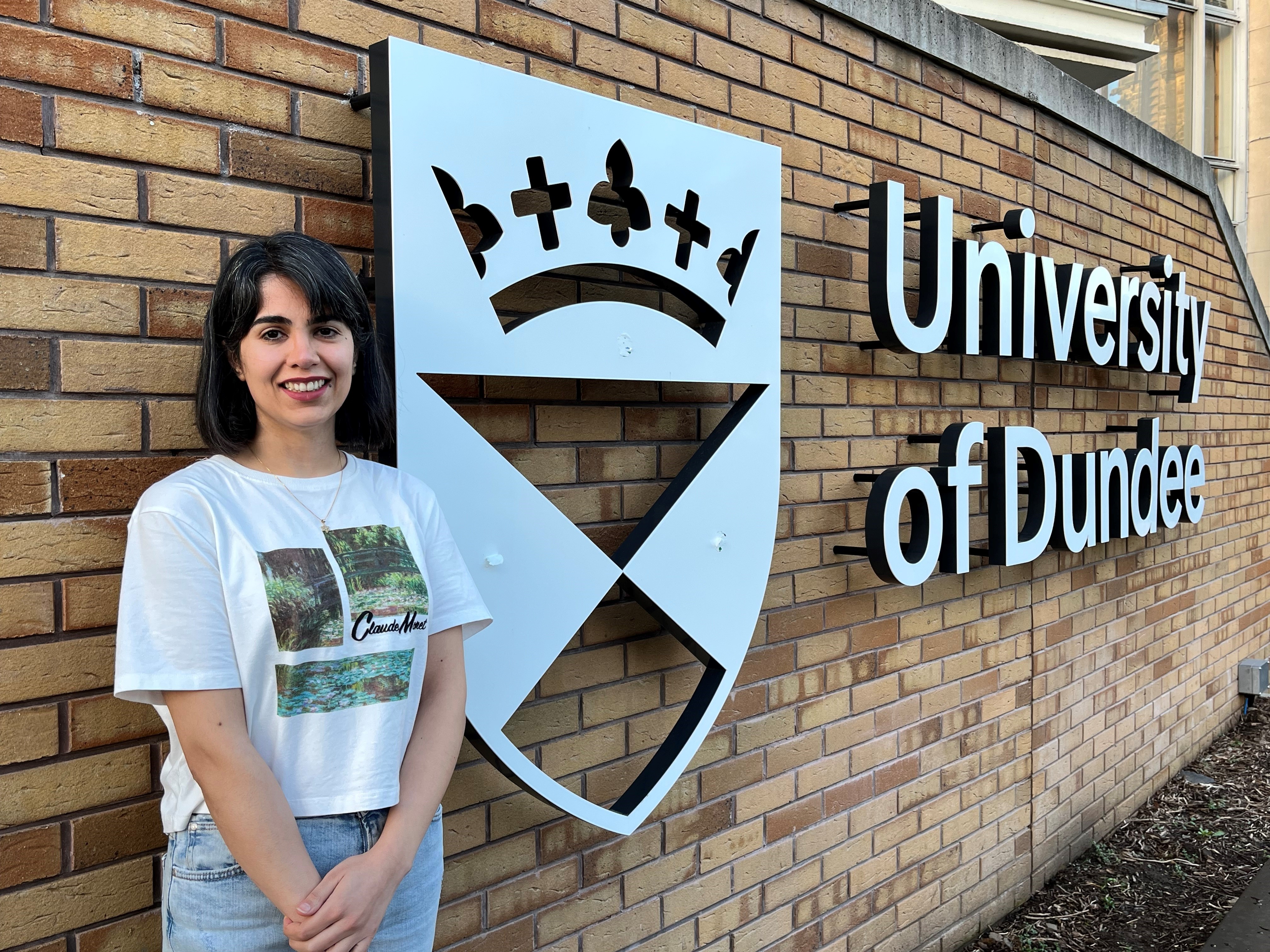 Mahtab Karami smiling next to a University of Dundee sign