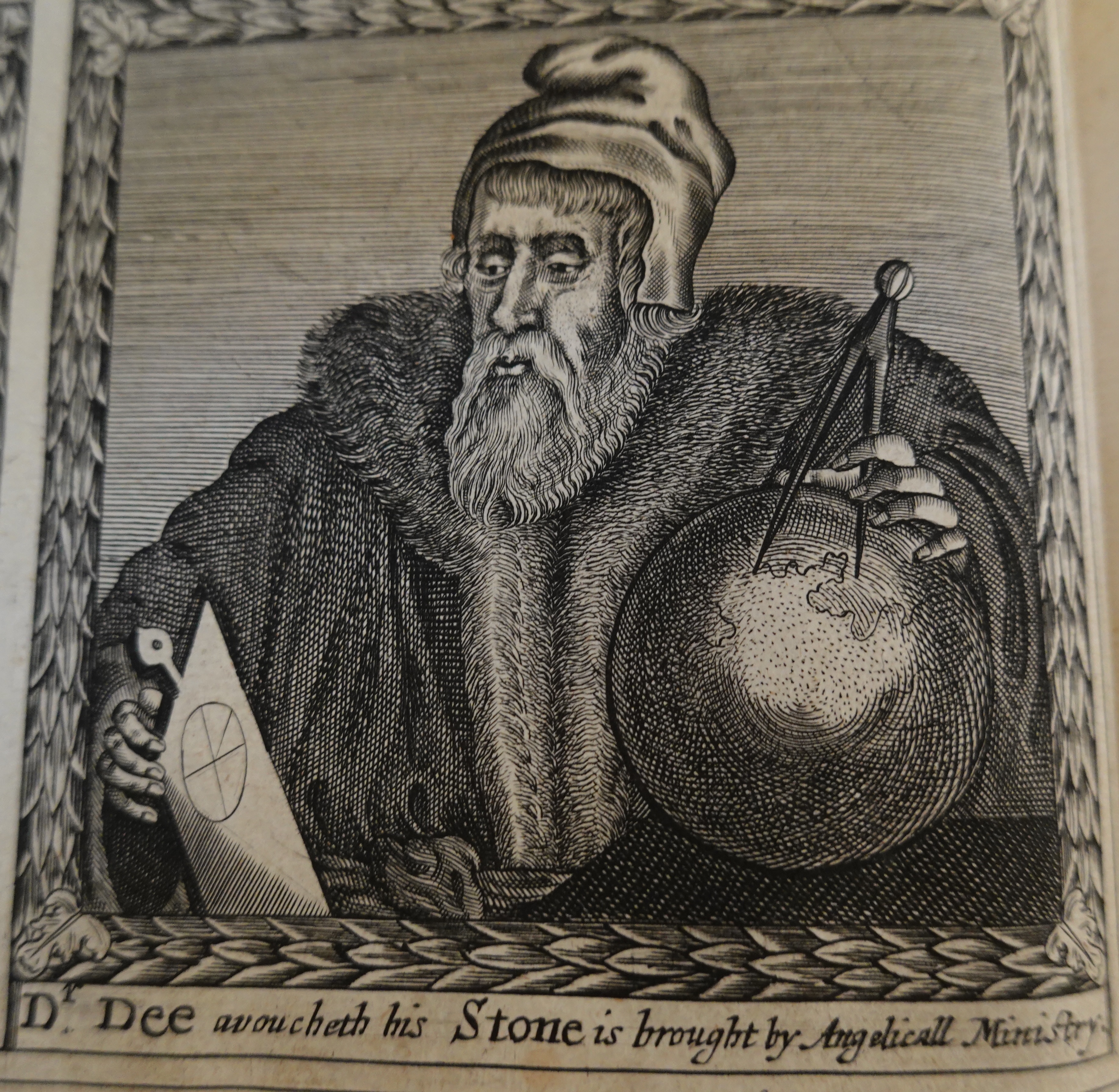 Close-up of a picture in an old book showing a bearded man in a fur-lined coat holding up a sphere with a pair of compasses on the top 