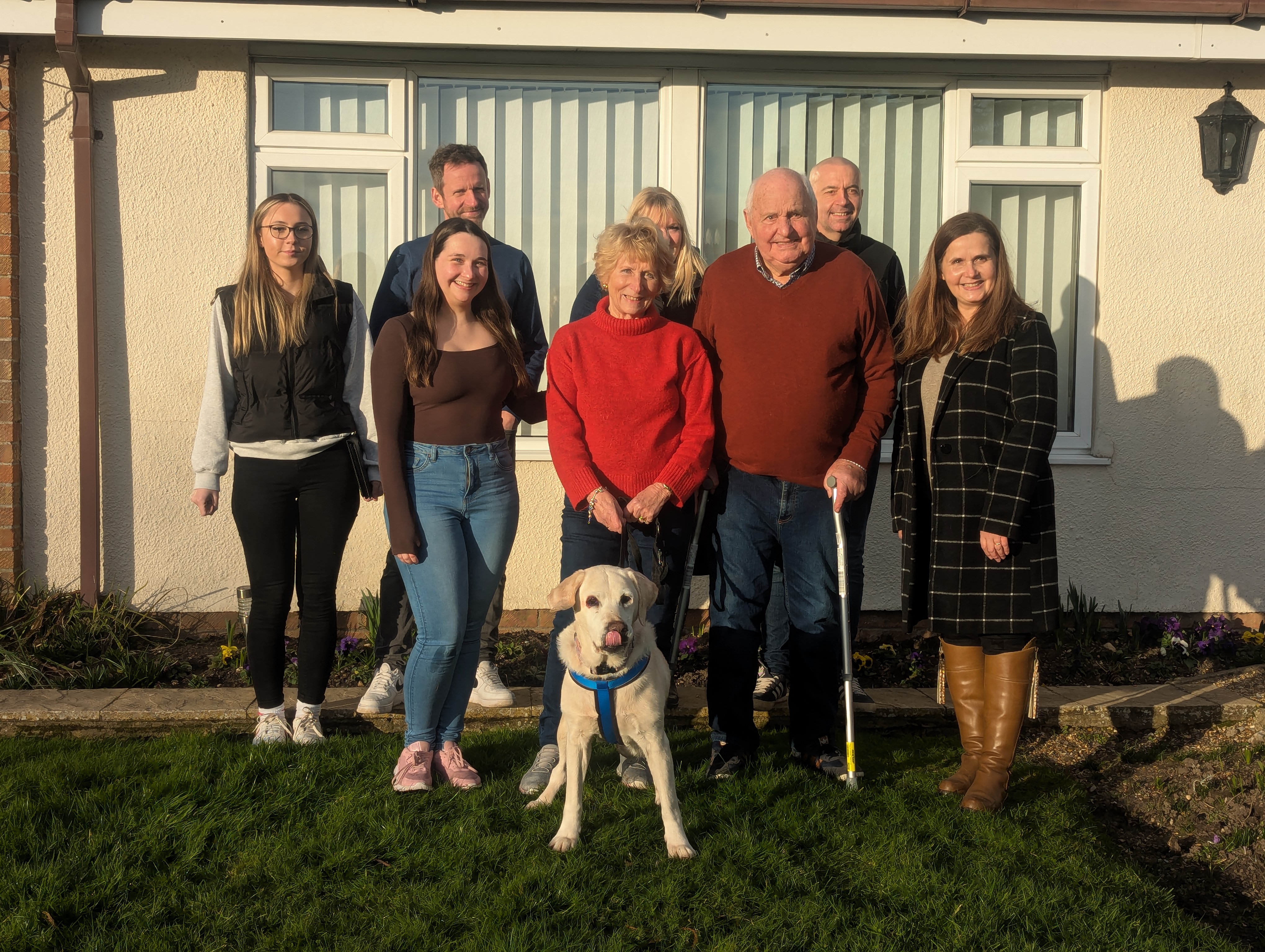 Family stood outside their home as they are reunited with their labrador