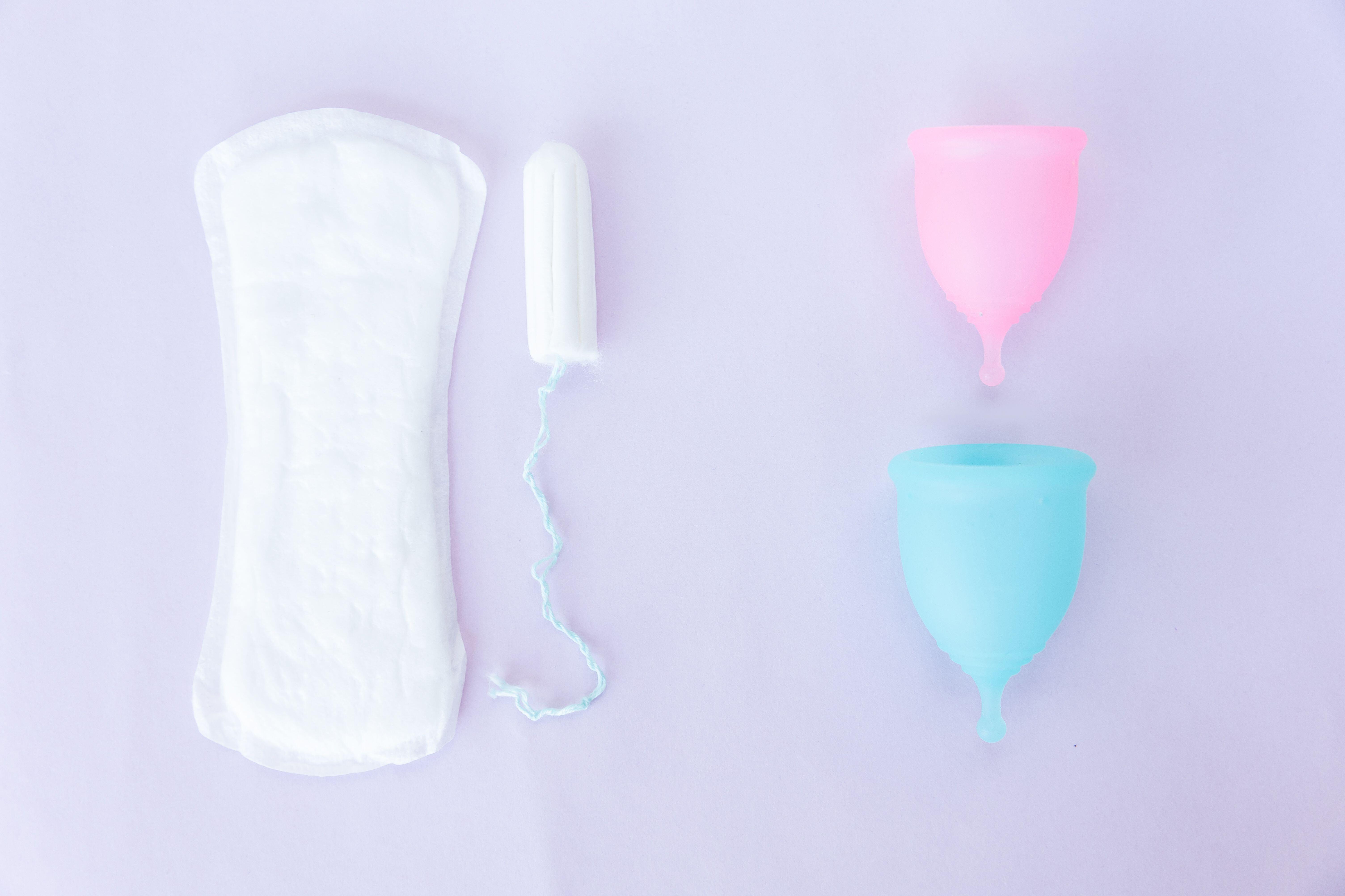 menstrual cups next to a pad and a tampon