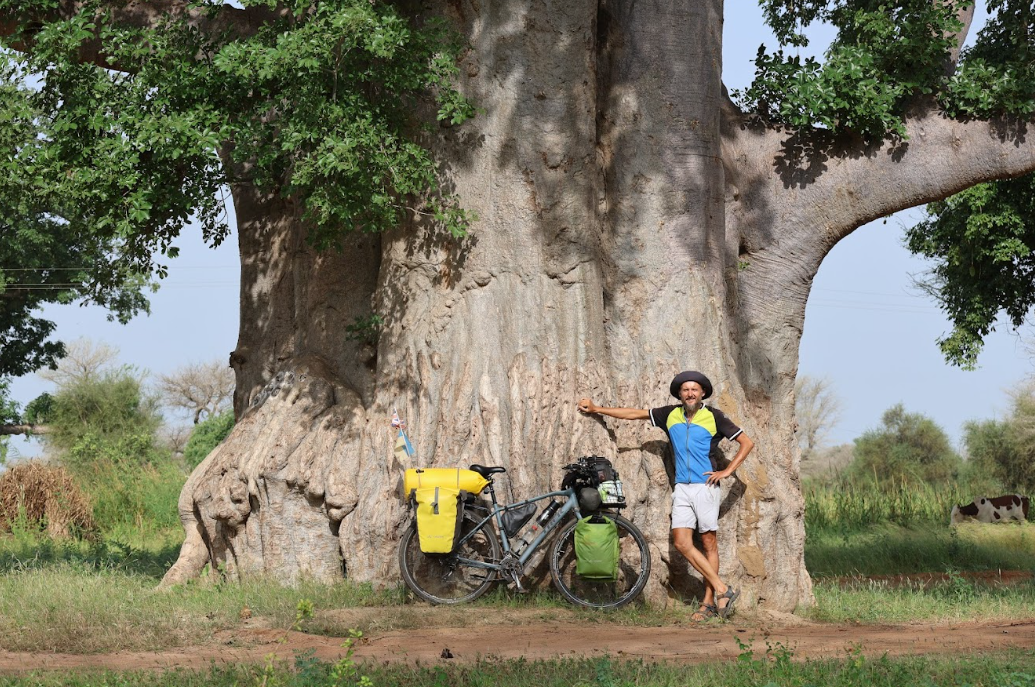 Volodymyr Muliar pictured in front of a huge tree in Senegal as part of a cycling adventure 