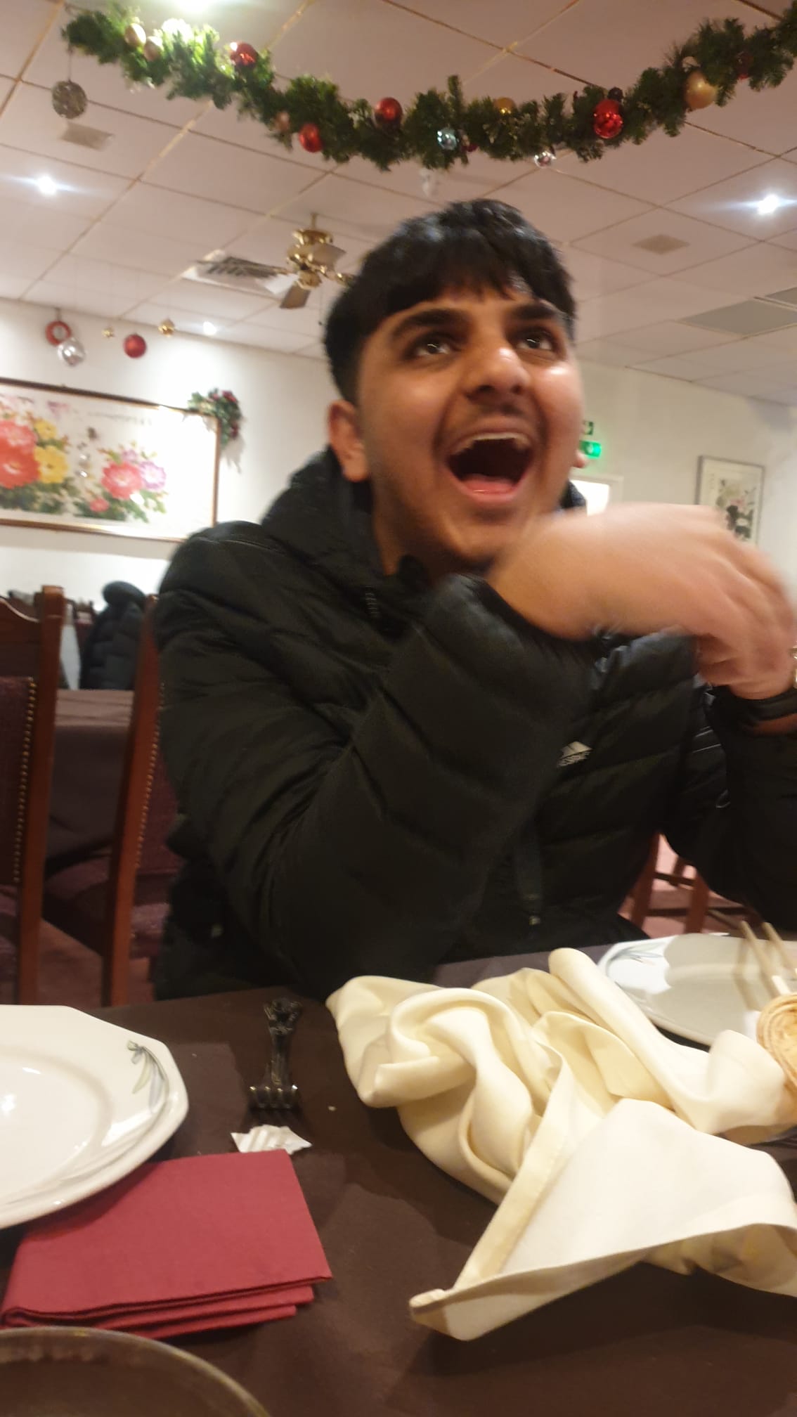 A boy smiling in a restaurant