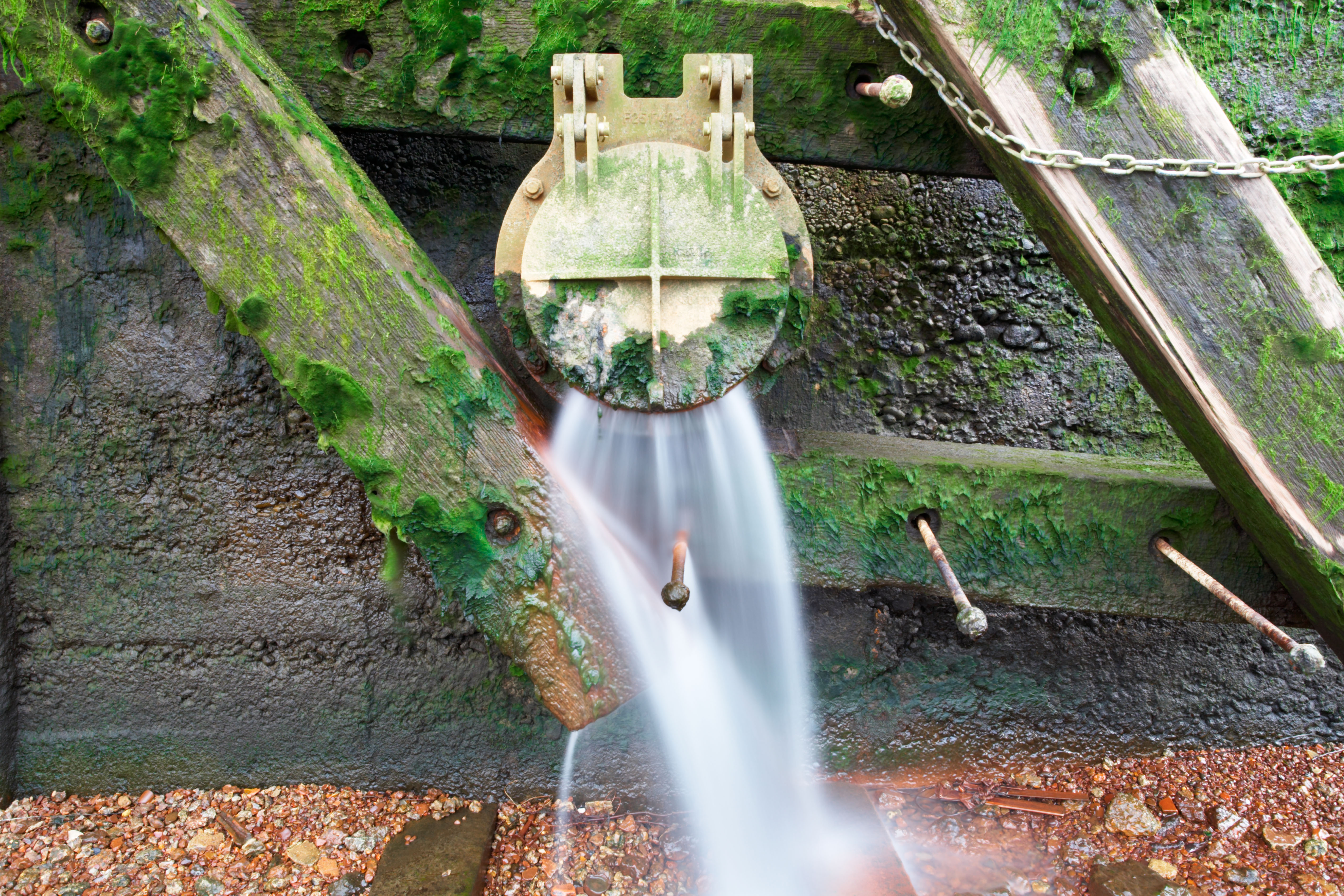 A storm overflow outlet with water pouring out 