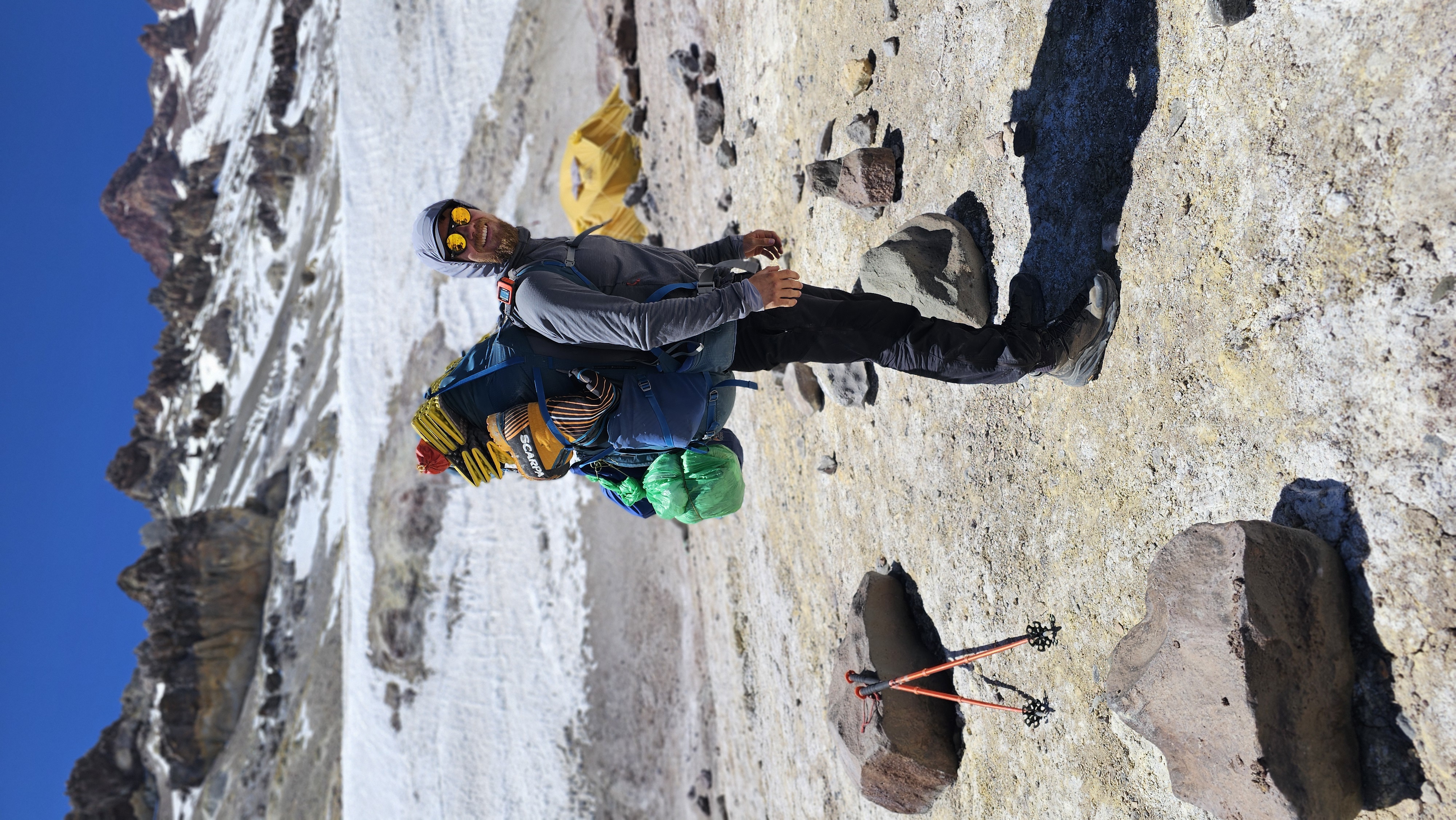 Man wearing a large rucksack carrying camping gear and equipment