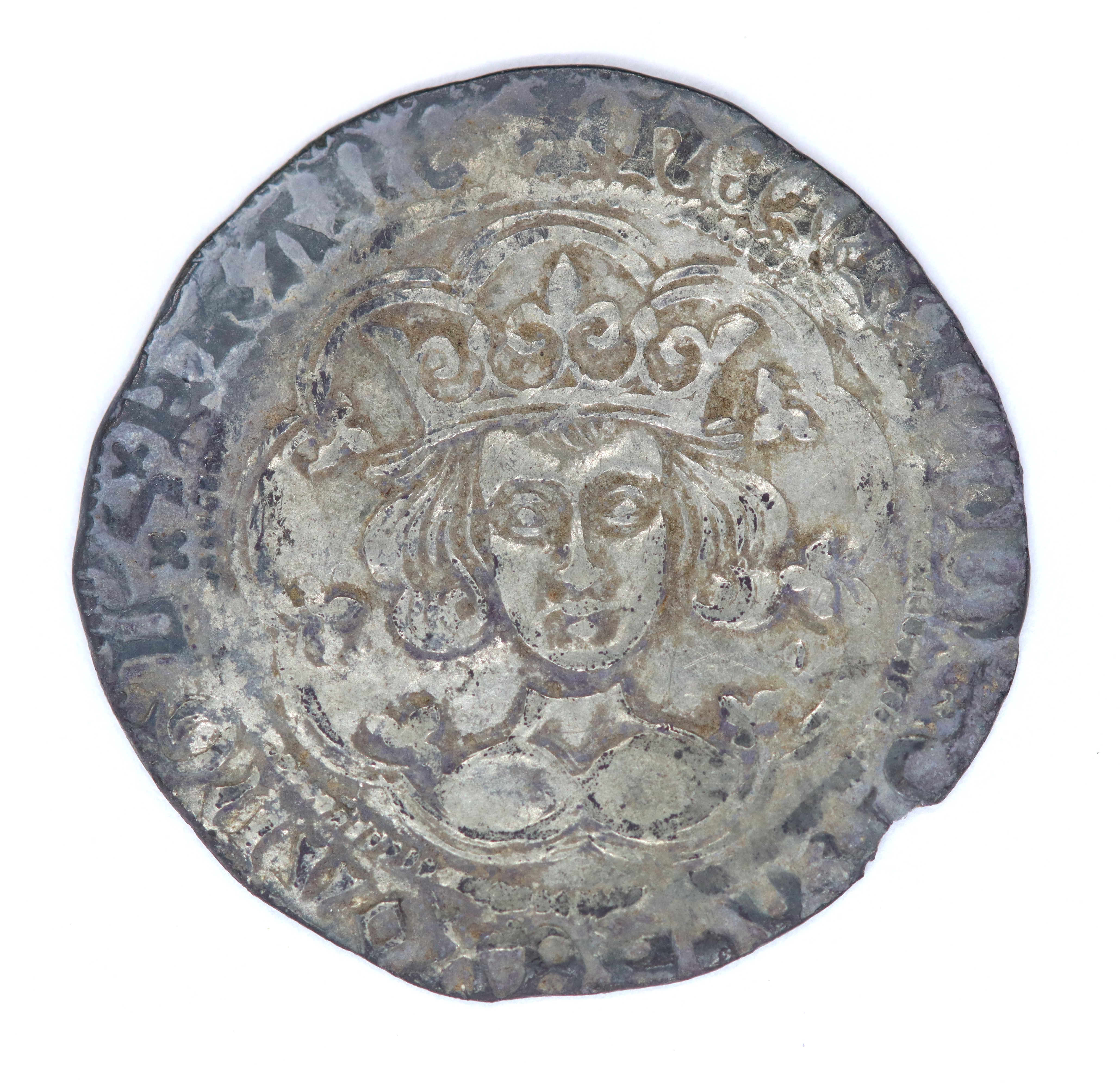 Silver coin with an image of a man wearing a crown