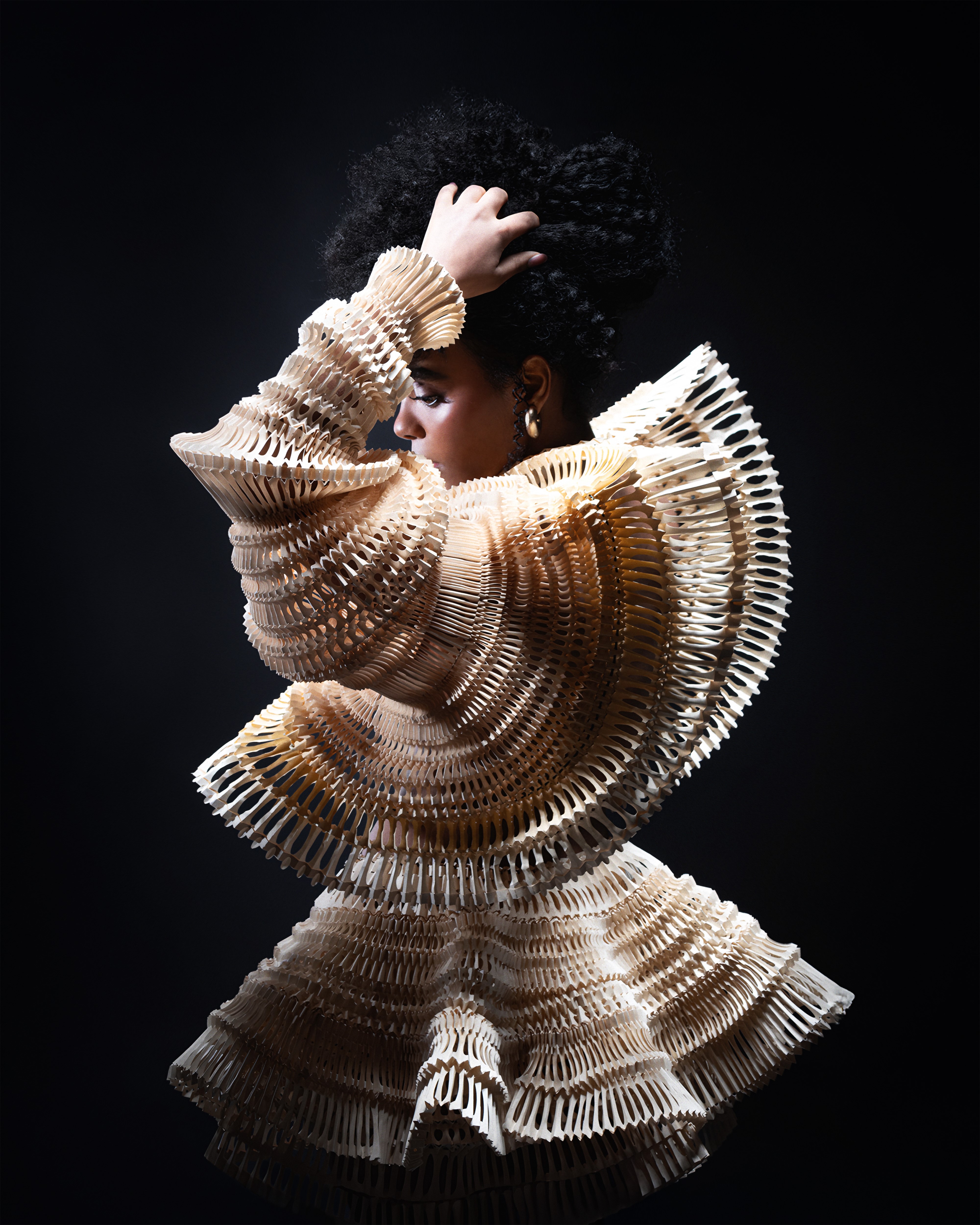 A woman wearing a dress made from paper using origami art