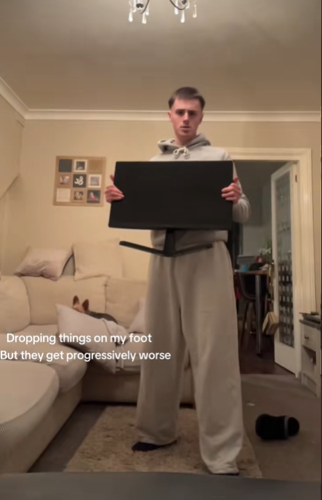 Screenshot from a TikTok video of a young man holding an computer monitor