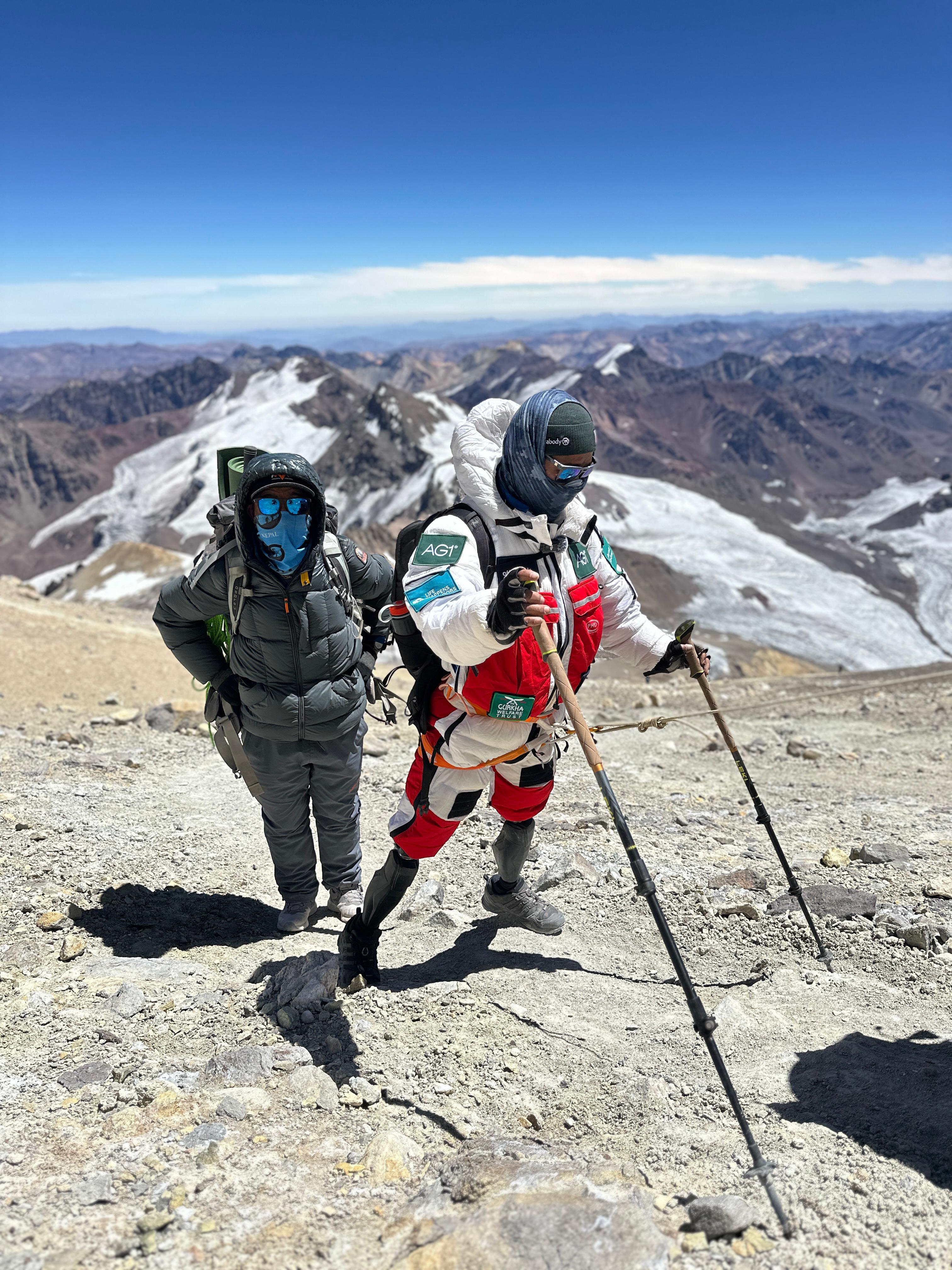 A man with prosthetic legs climbing a mountain 