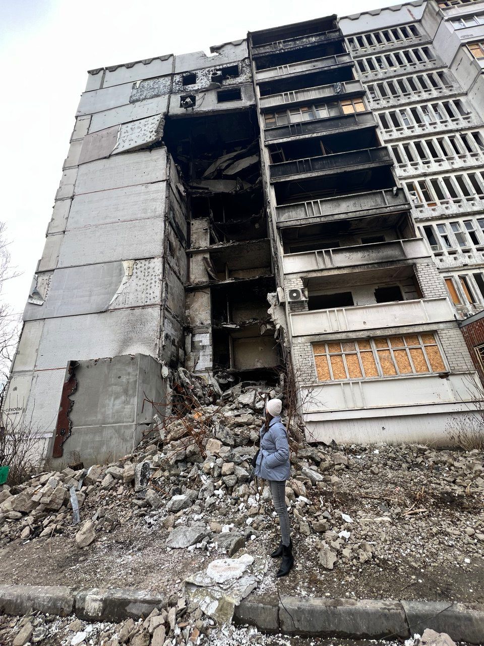 A woman standing in front of rubble