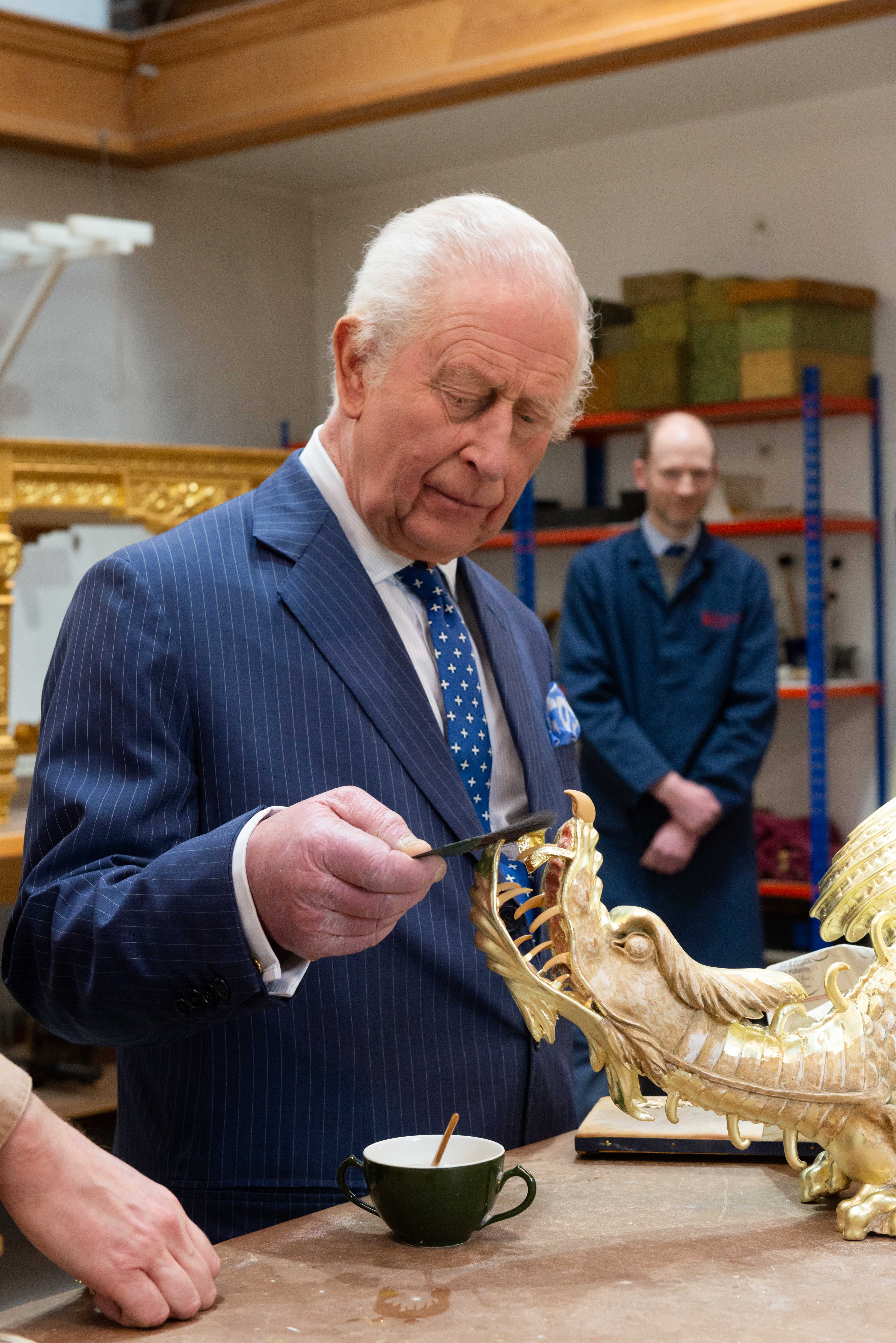 The King concentrates as he applies gold leaf to the dragon