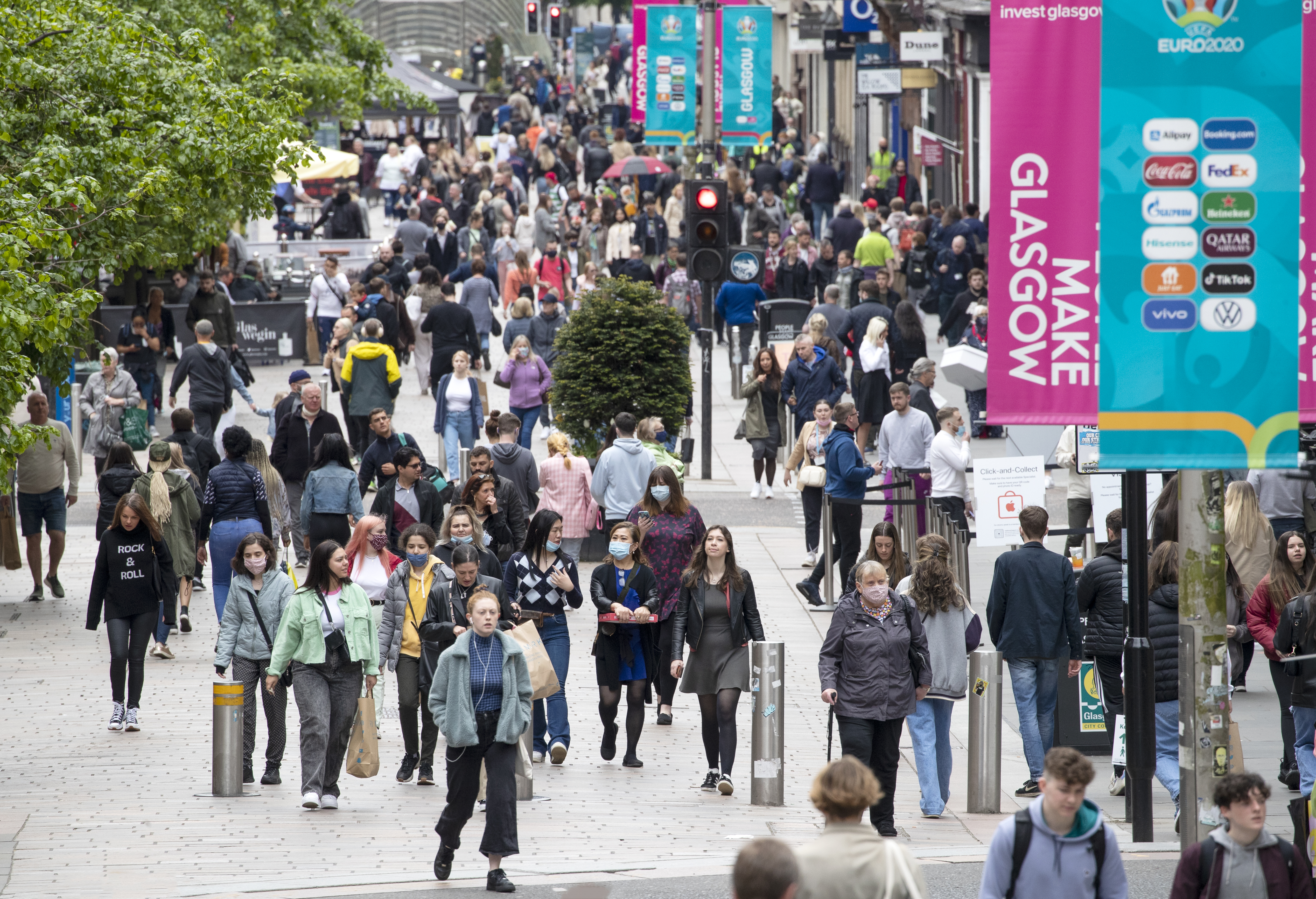 Shoppers walk down a road in Glasgow