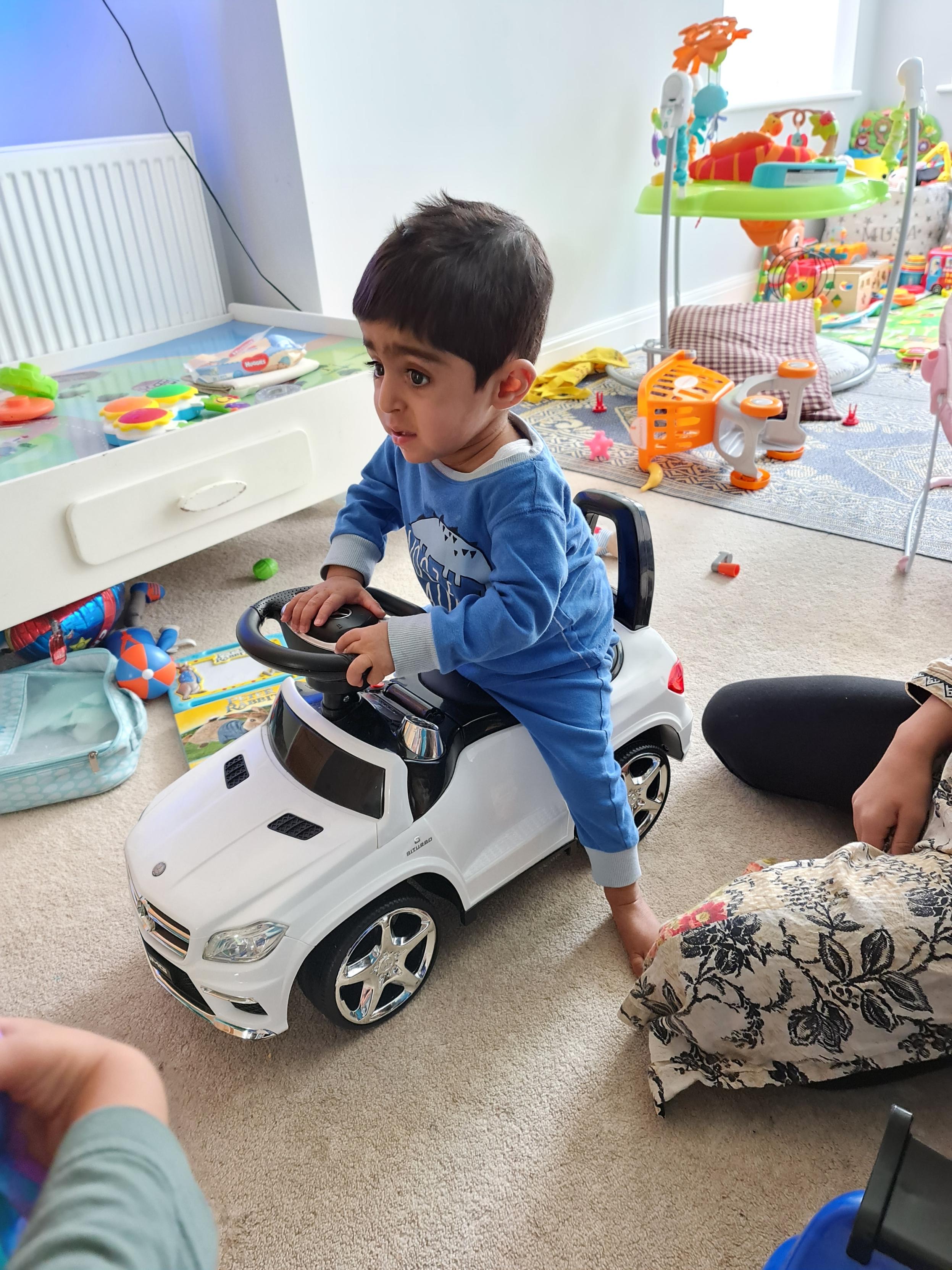 Eisa sits on a toy car